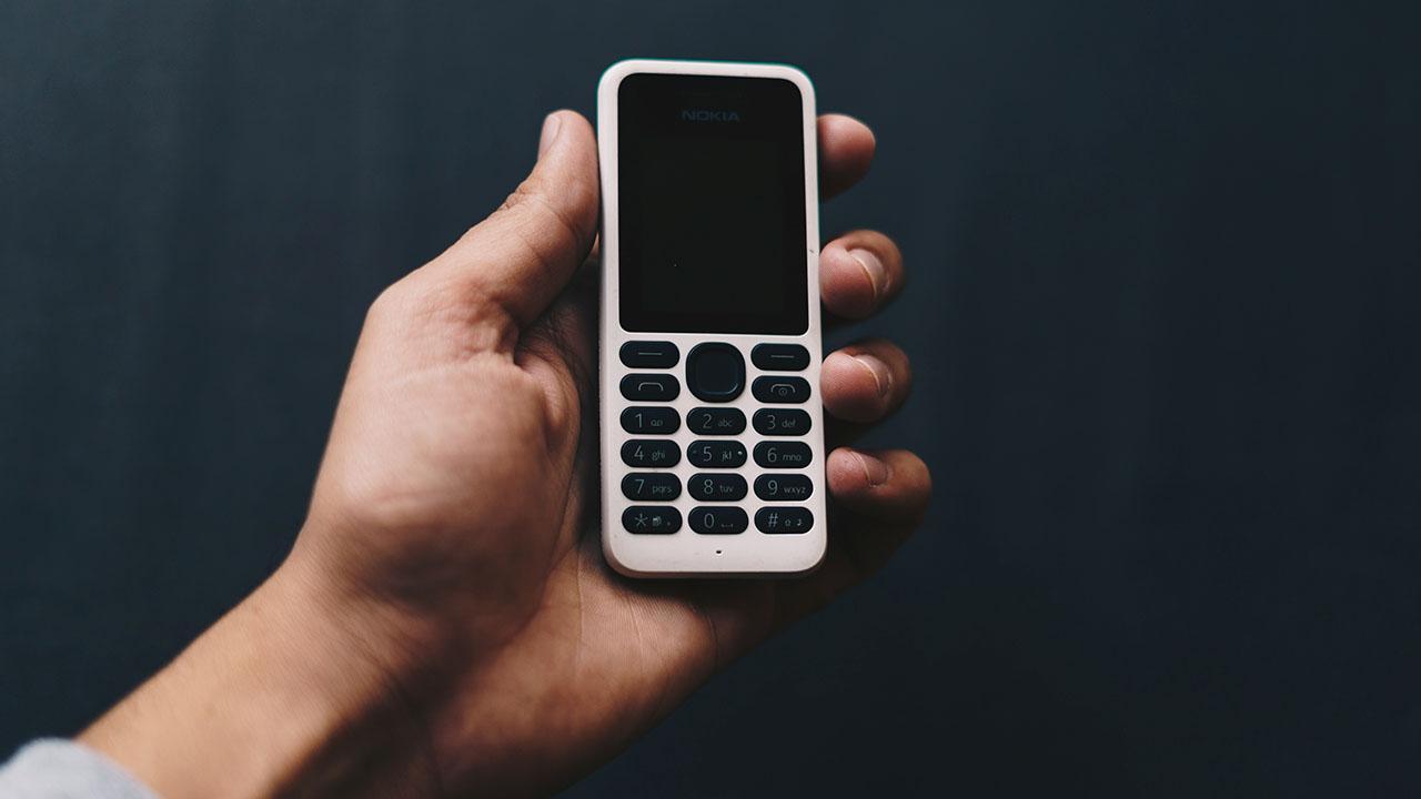 Jóvenes usando dumbphones