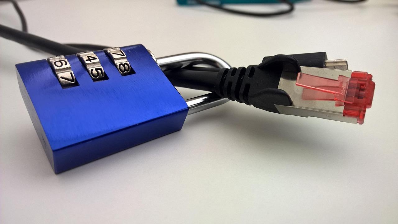 Candado físico sobre un cable de red, simbolizando el cifrado de datos y la protección de la información transmitida a través de internet.