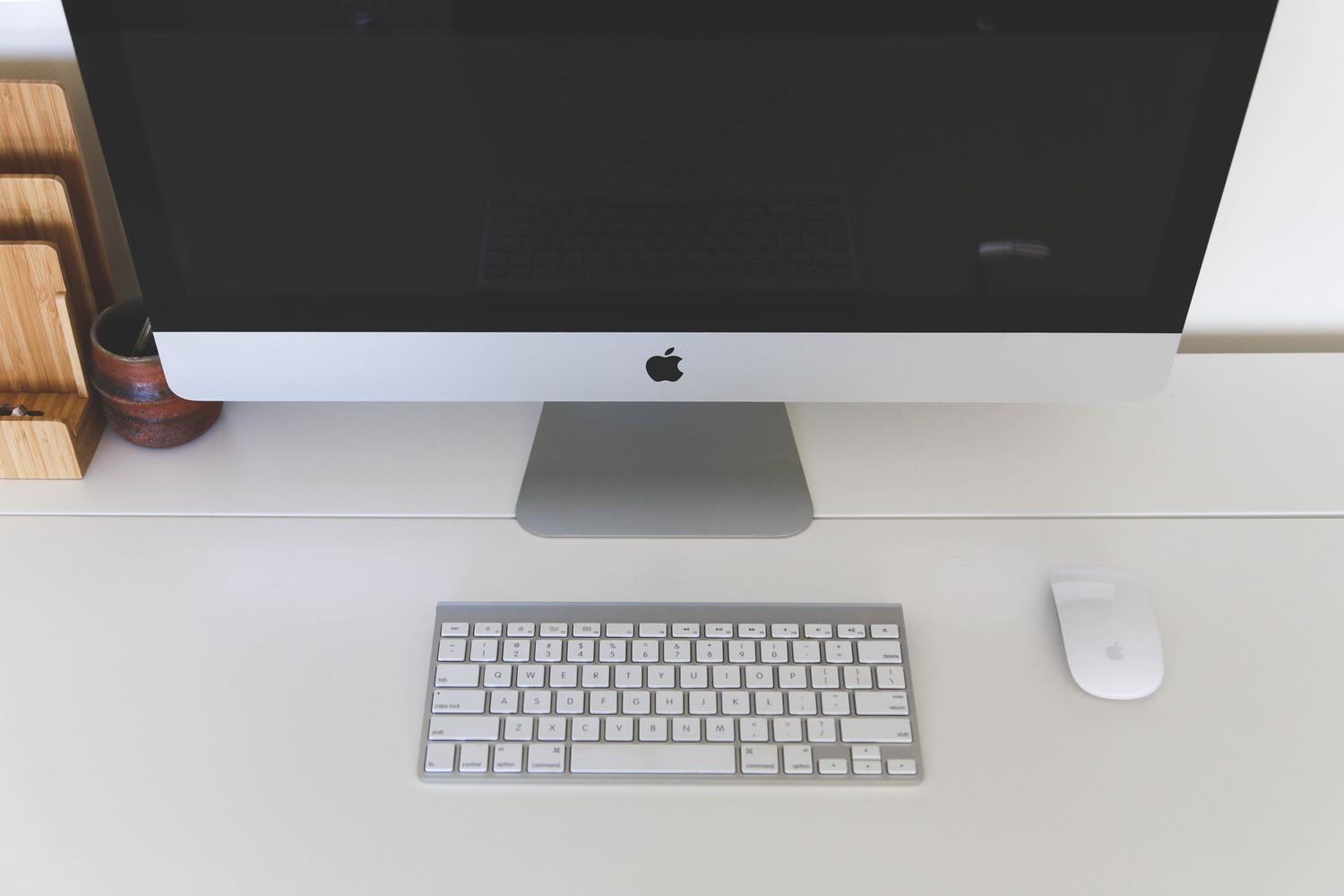 Escritorio de oficina limpio con un ordenador iMac, representando un espacio de trabajo digital sin distracciones.