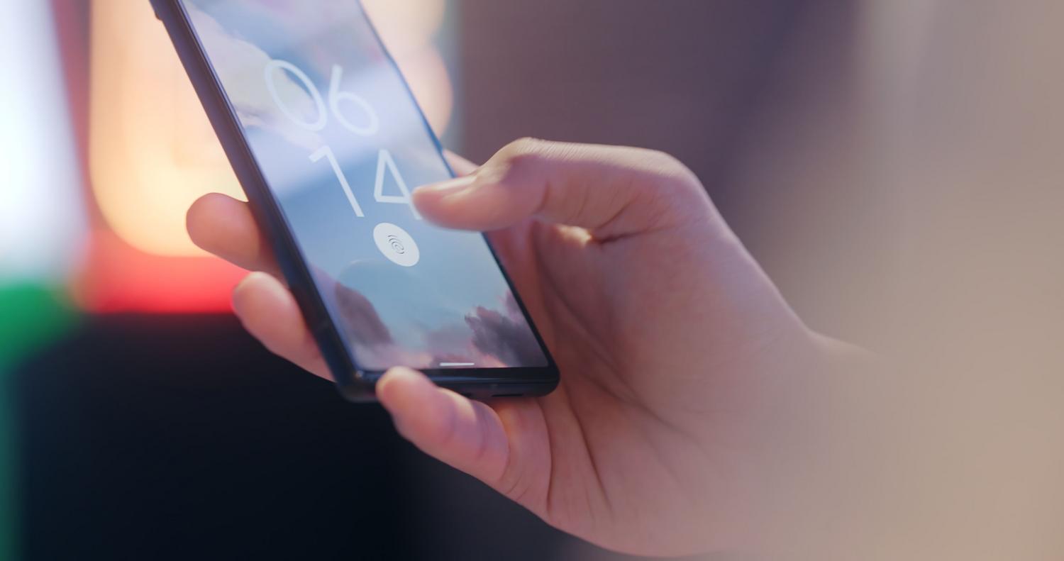 Primer plano de un smartphone con sensor de huella dactilar para representar la autenticación biométrica, las llaves de acceso y la verificación en dos pasos.