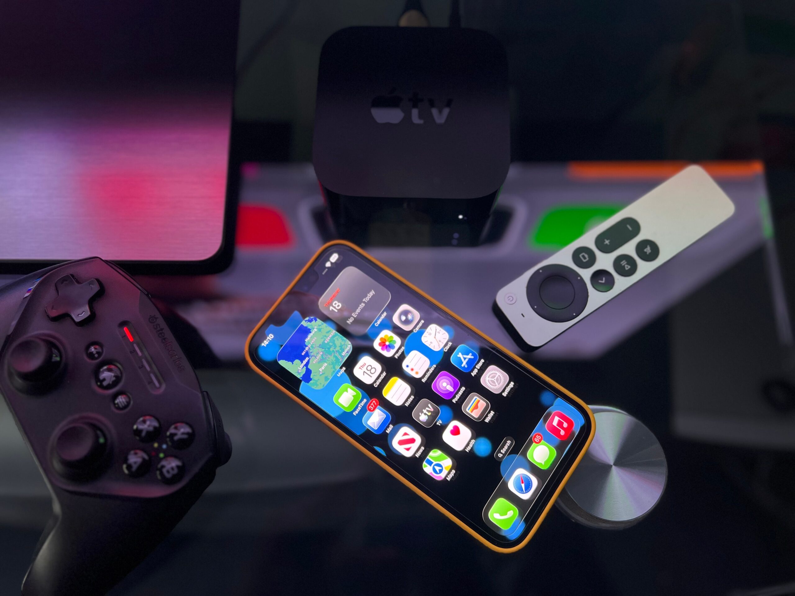 Dispositivos de entretenimiento modernos incluyendo un decodificador de streaming, smartphone y mando de juegos.