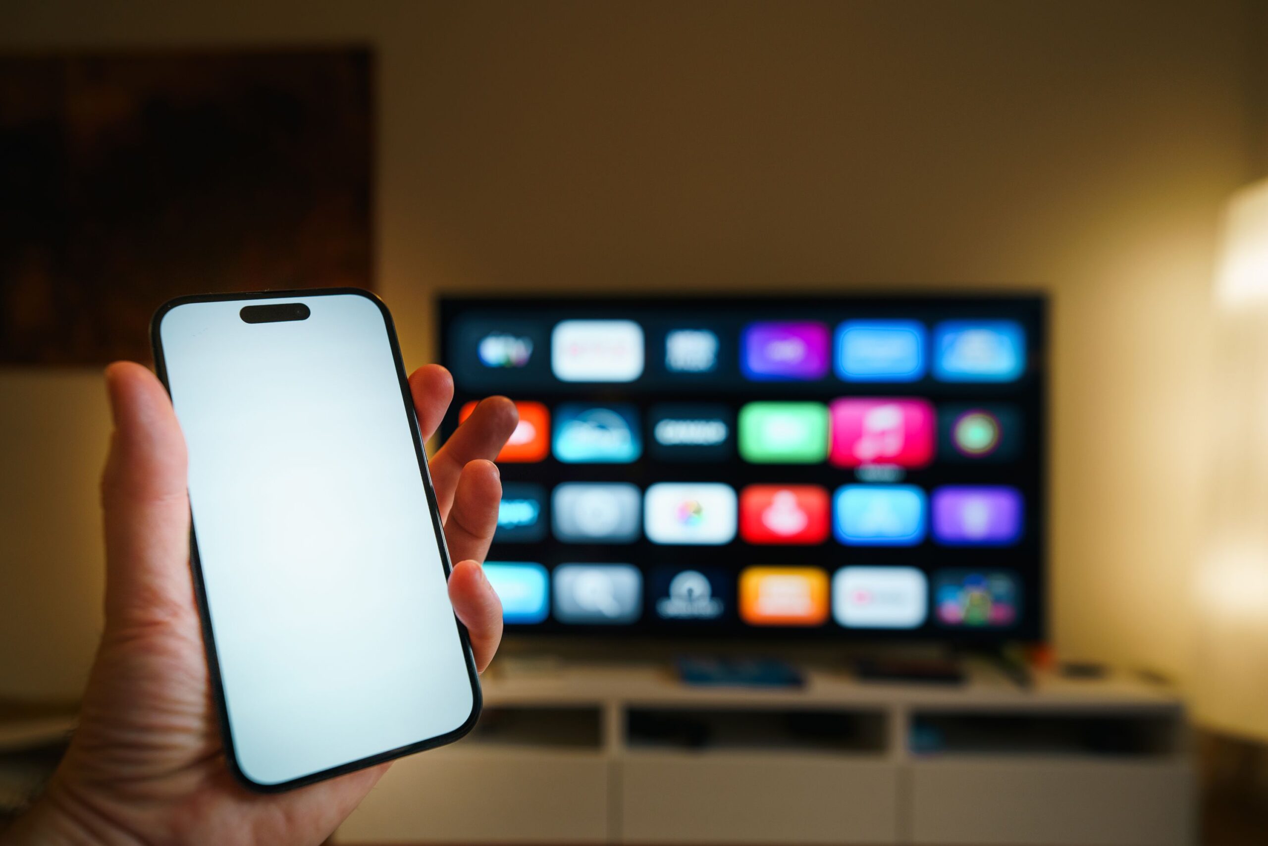 Uso de smartphone para gestionar aplicaciones de streaming en una Smart TV en un salón acogedor