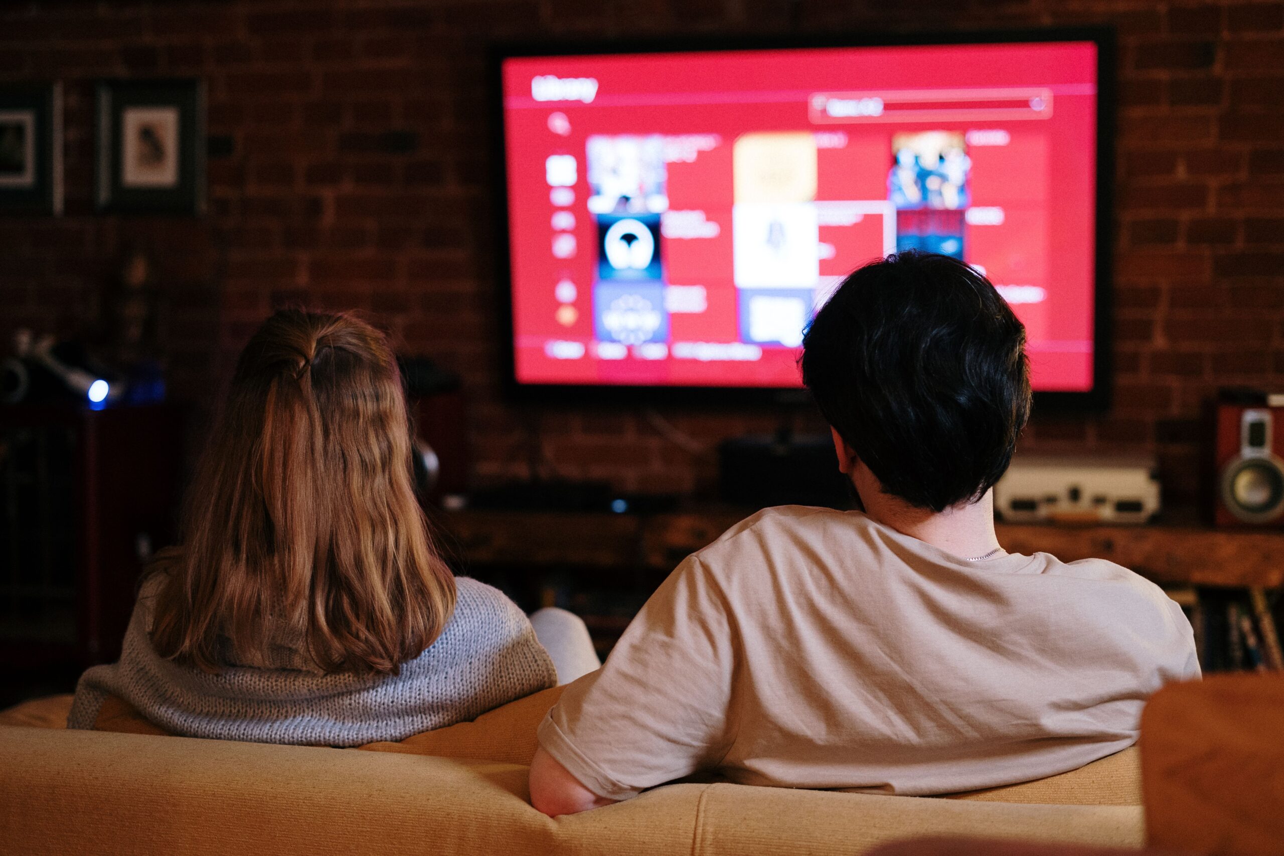 Pareja disfrutando de una película en un ambiente acogedor con sistema de audio optimizado
