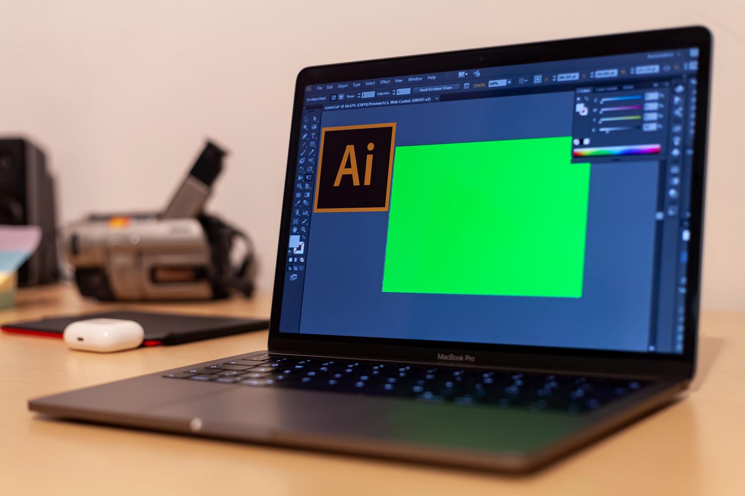 Primer plano de un MacBook Pro con Adobe Illustrator abierto, ilustrando el flujo de trabajo creativo en macOS.