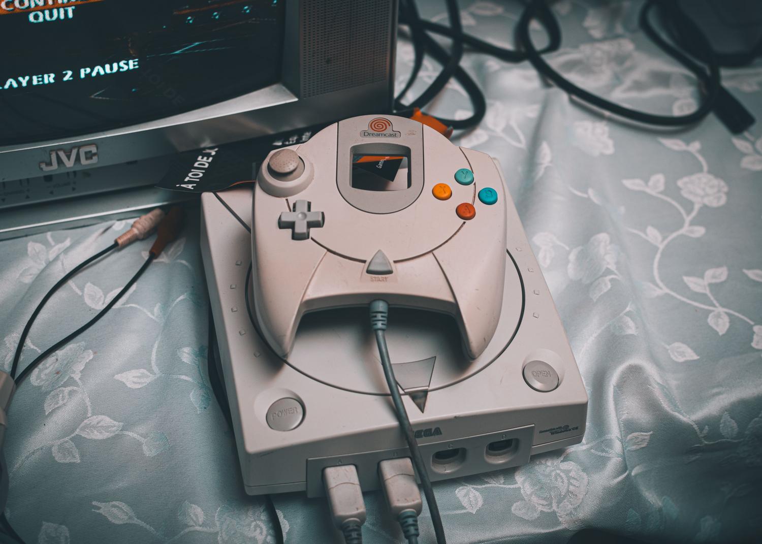 Consola Sega Dreamcast con monitor CRT y cables RCA, representando la configuración retro original.
