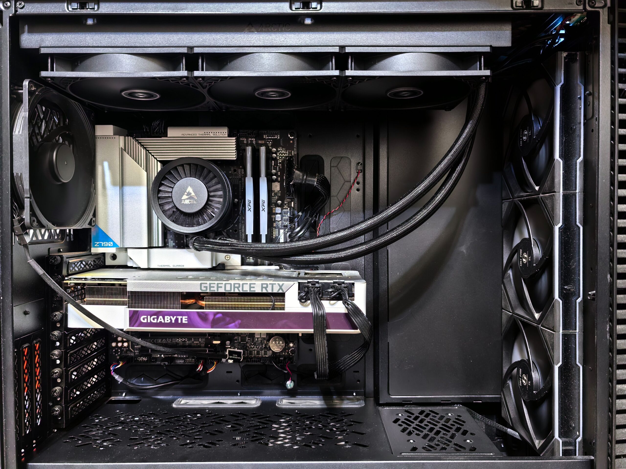 Vista interior de un PC gaming mostrando una tarjeta gráfica GeForce RTX y un sistema de refrigeración líquida AIO.