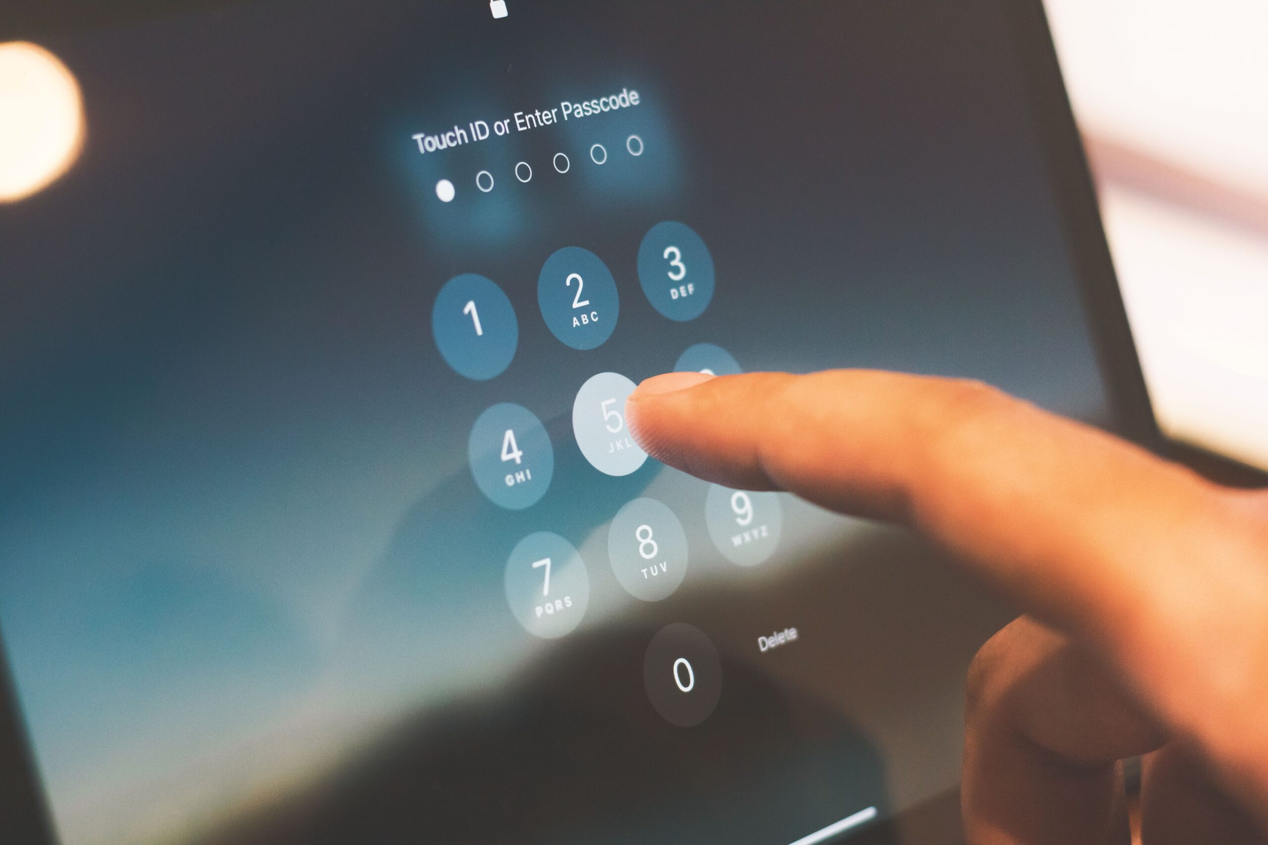 Dedo introduciendo un código de seguridad en la pantalla de bloqueo de un smartphone.