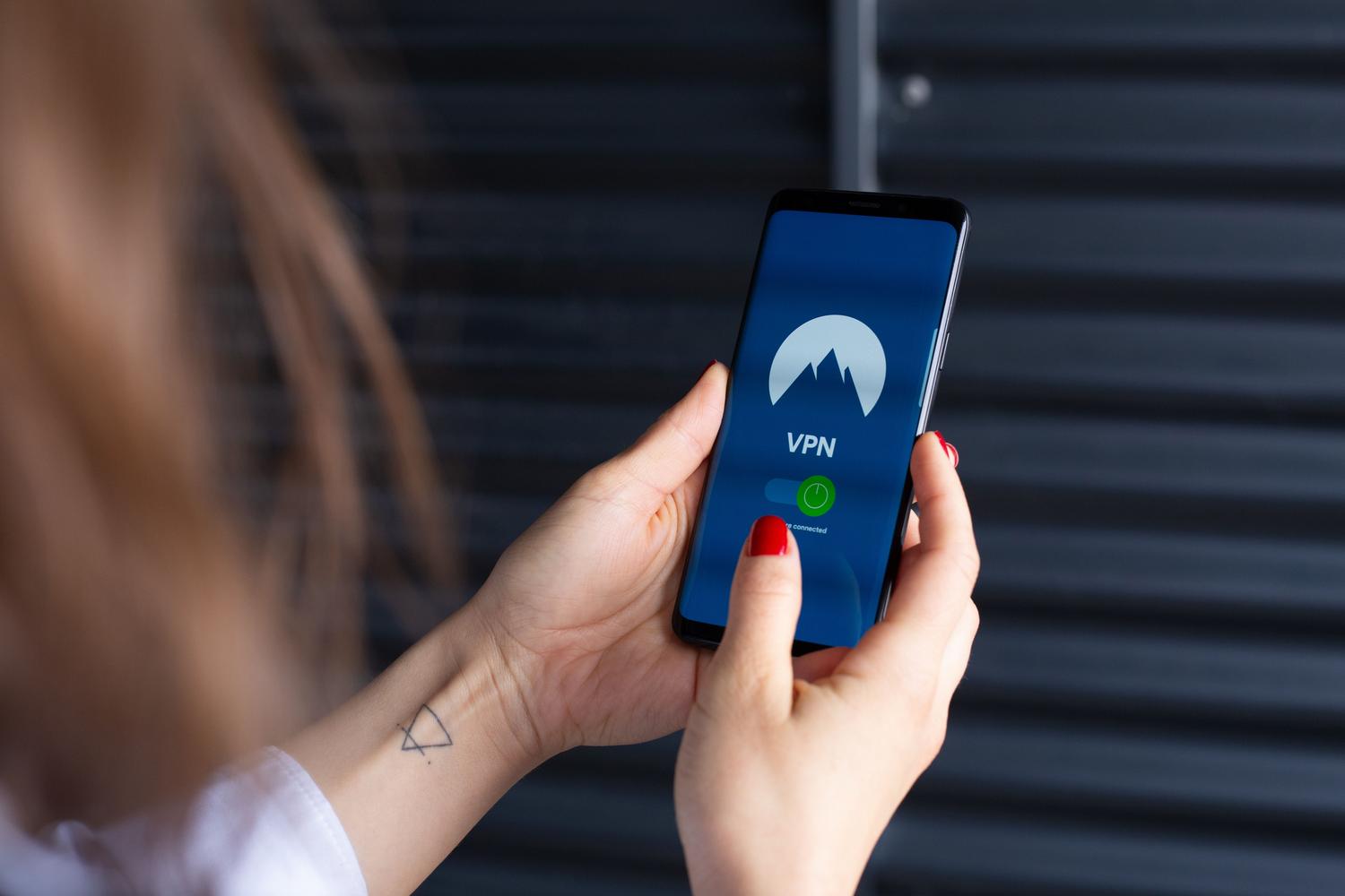 Primer plano de una persona activando una aplicación de VPN en su smartphone para navegar de forma segura.