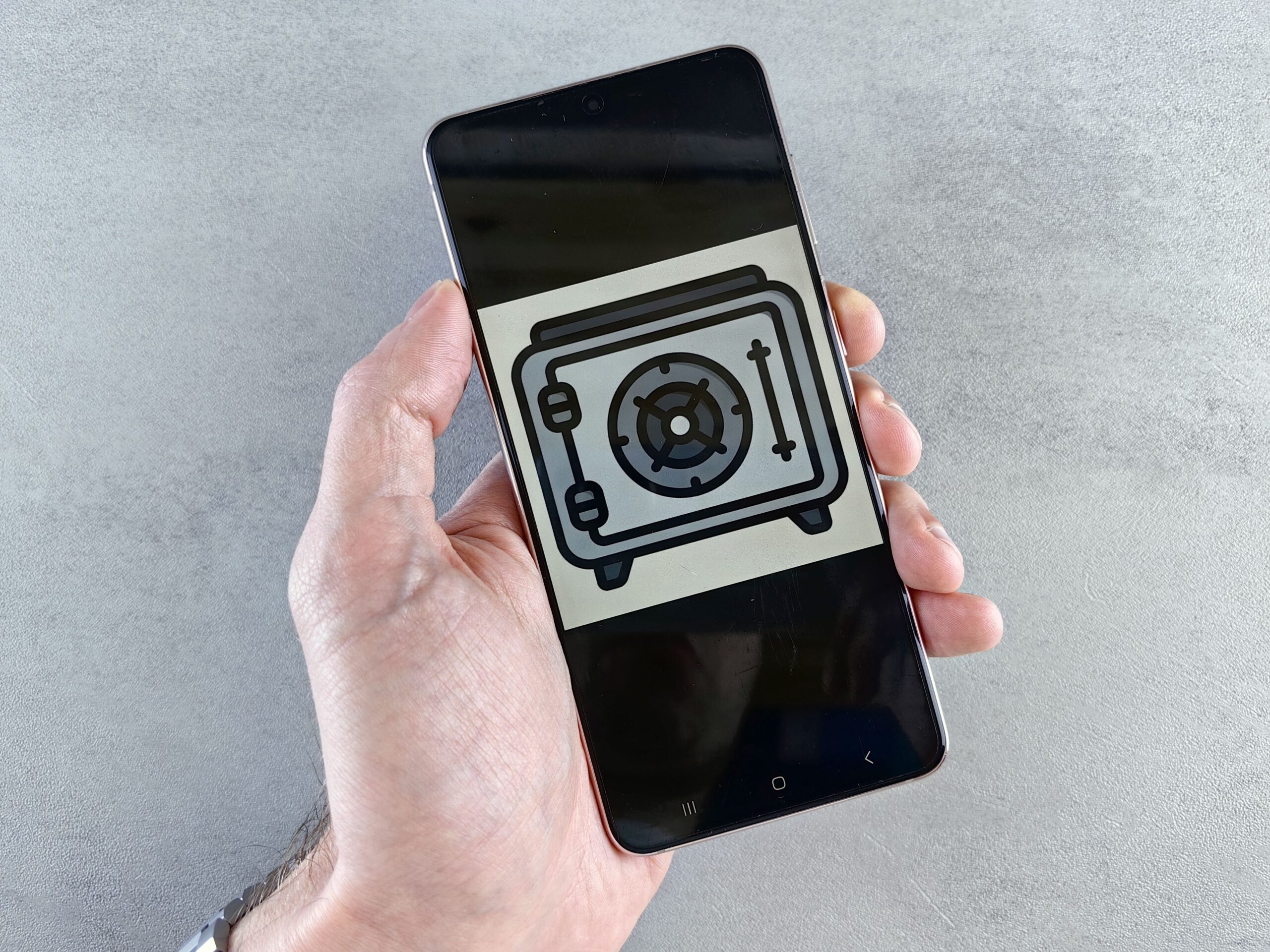 Smartphone mostrando un icono de caja fuerte en la pantalla, representando el almacenamiento seguro de información personal.