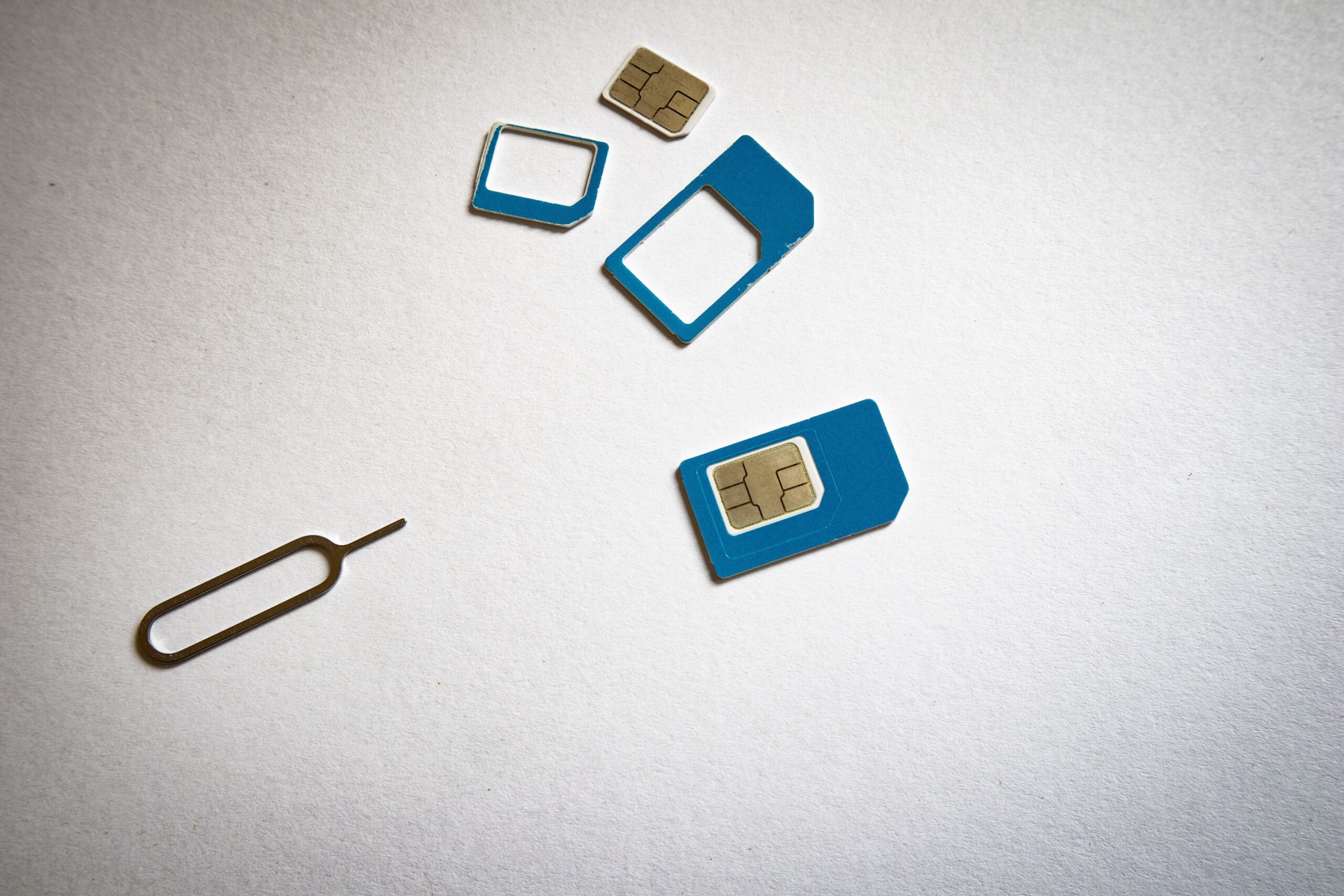 Tarjeta SIM y herramienta de extracción sobre fondo blanco, representando el mantenimiento del hardware del móvil