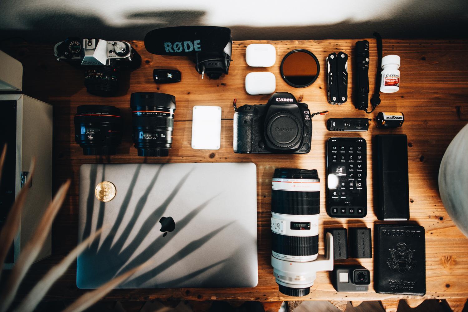 Disposición organizada de equipo fotográfico y videográfico incluyendo cámaras y un MacBook, mostrando el flujo desde la captura hasta la edición.