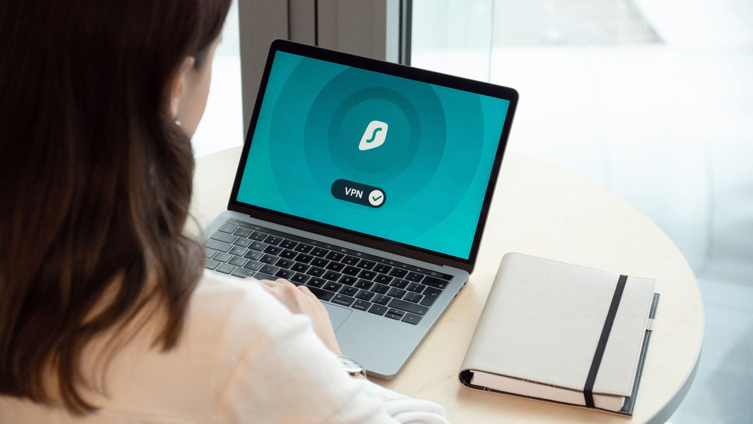 Persona utilizando un ordenador portátil con una conexión VPN activa para el acceso remoto seguro a un servidor.