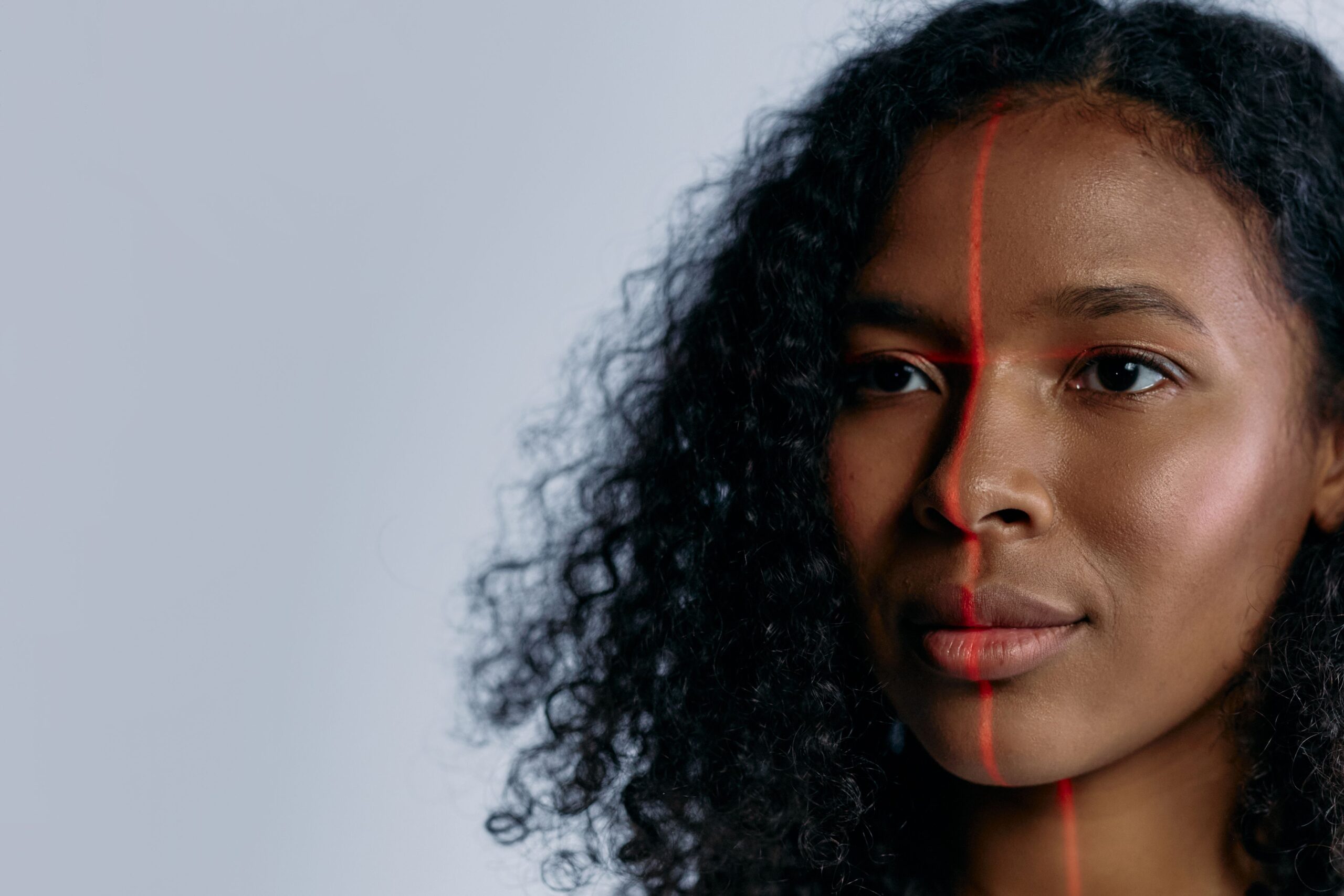 Escaneo de reconocimiento facial futurista con líneas láser sobre el rostro de una mujer, representando la autenticación facial de Windows Hello.