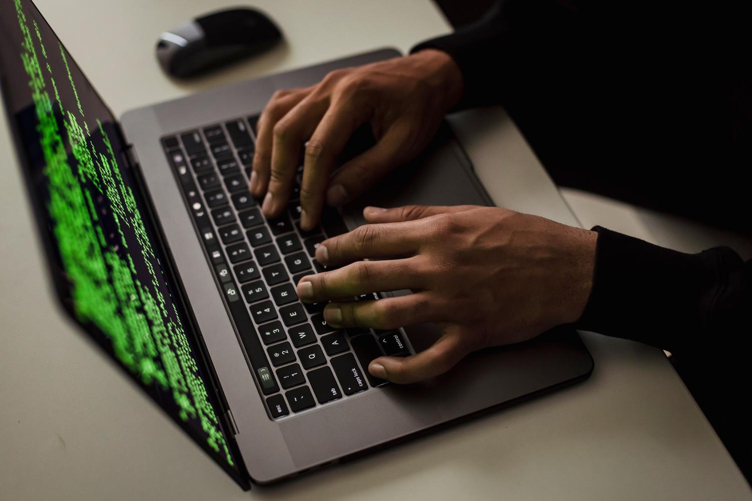 Persona anónima escribiendo en un portátil en un entorno oscuro, ilustrando los riesgos de seguridad y los intentos de evasión.
