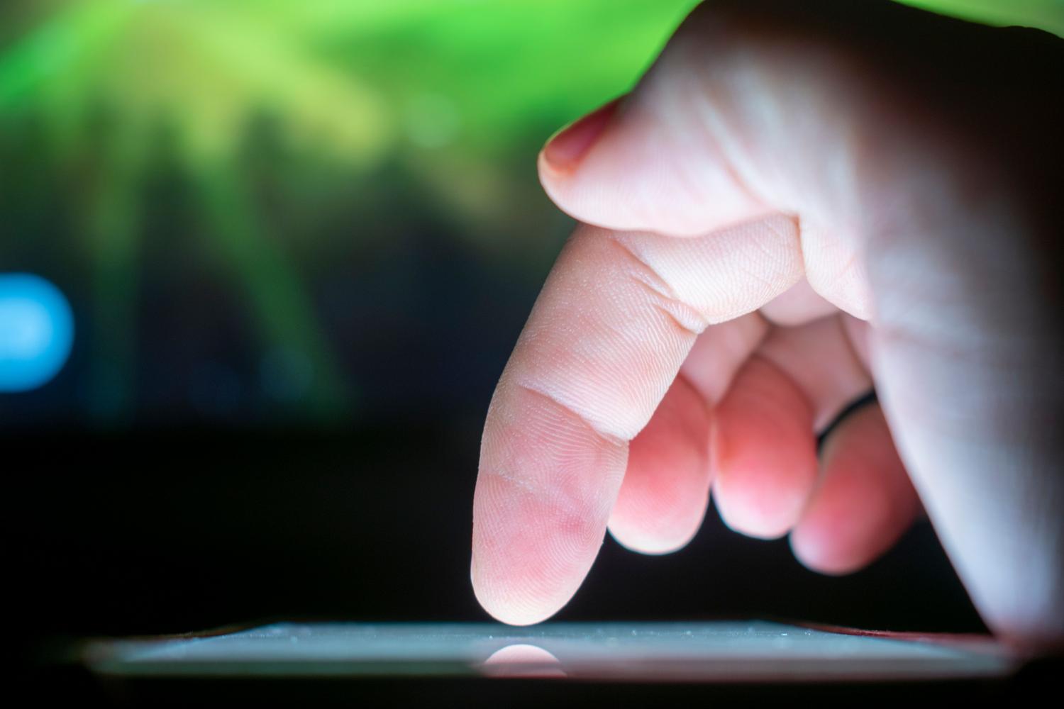 Primer plano de un dedo interactuando con la pantalla táctil de un dispositivo móvil.
