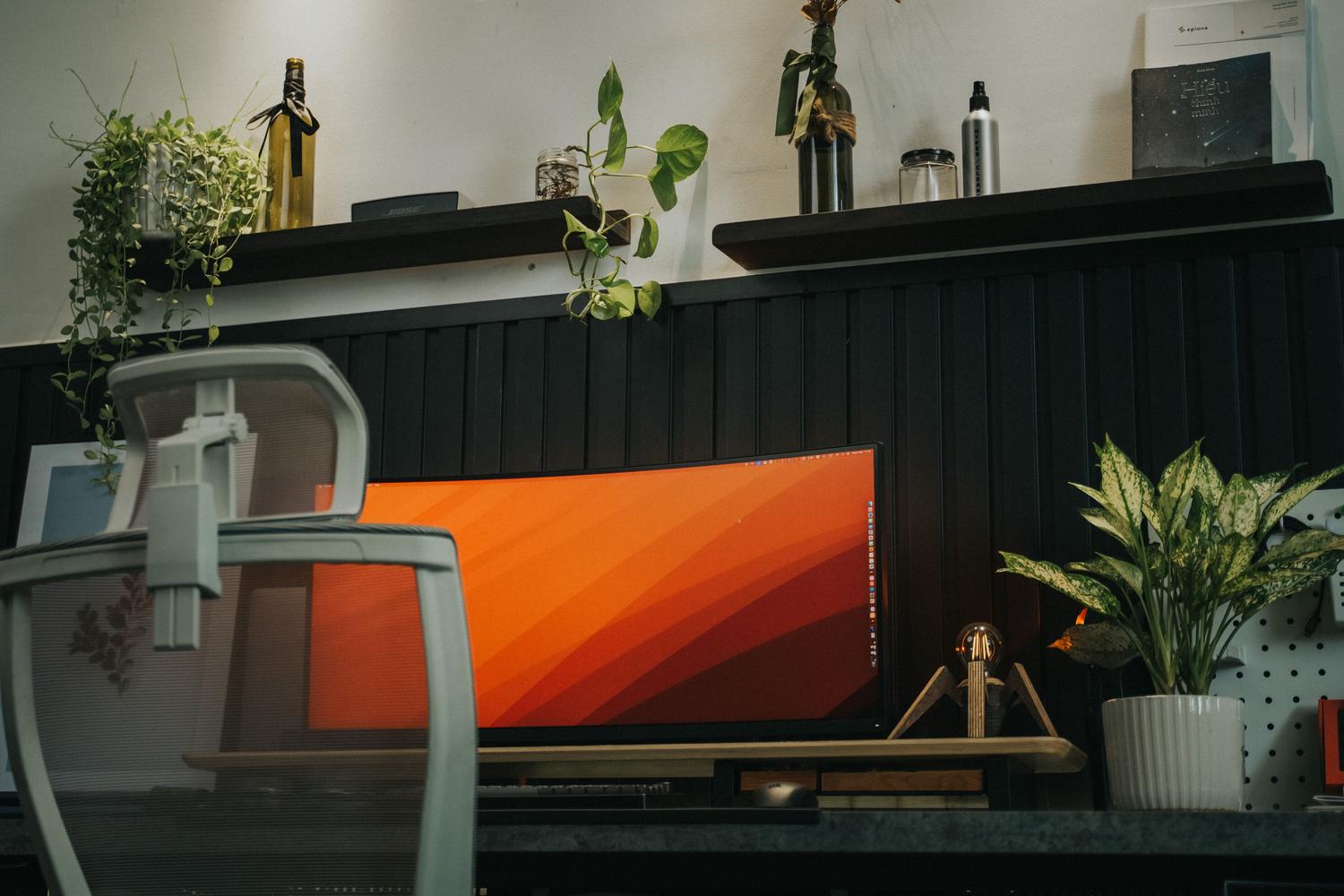 Configuración de escritorio minimalista y limpia con un monitor curvo ultrapanorámico en un entorno productivo.