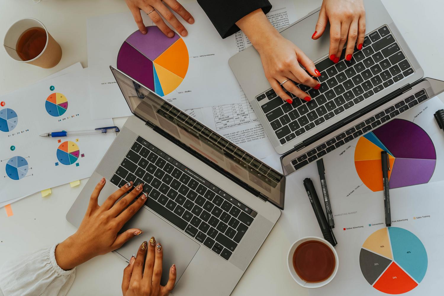 Equipo de trabajo colaborando con portátiles y gráficos, simbolizando la interoperabilidad de datos complejos.