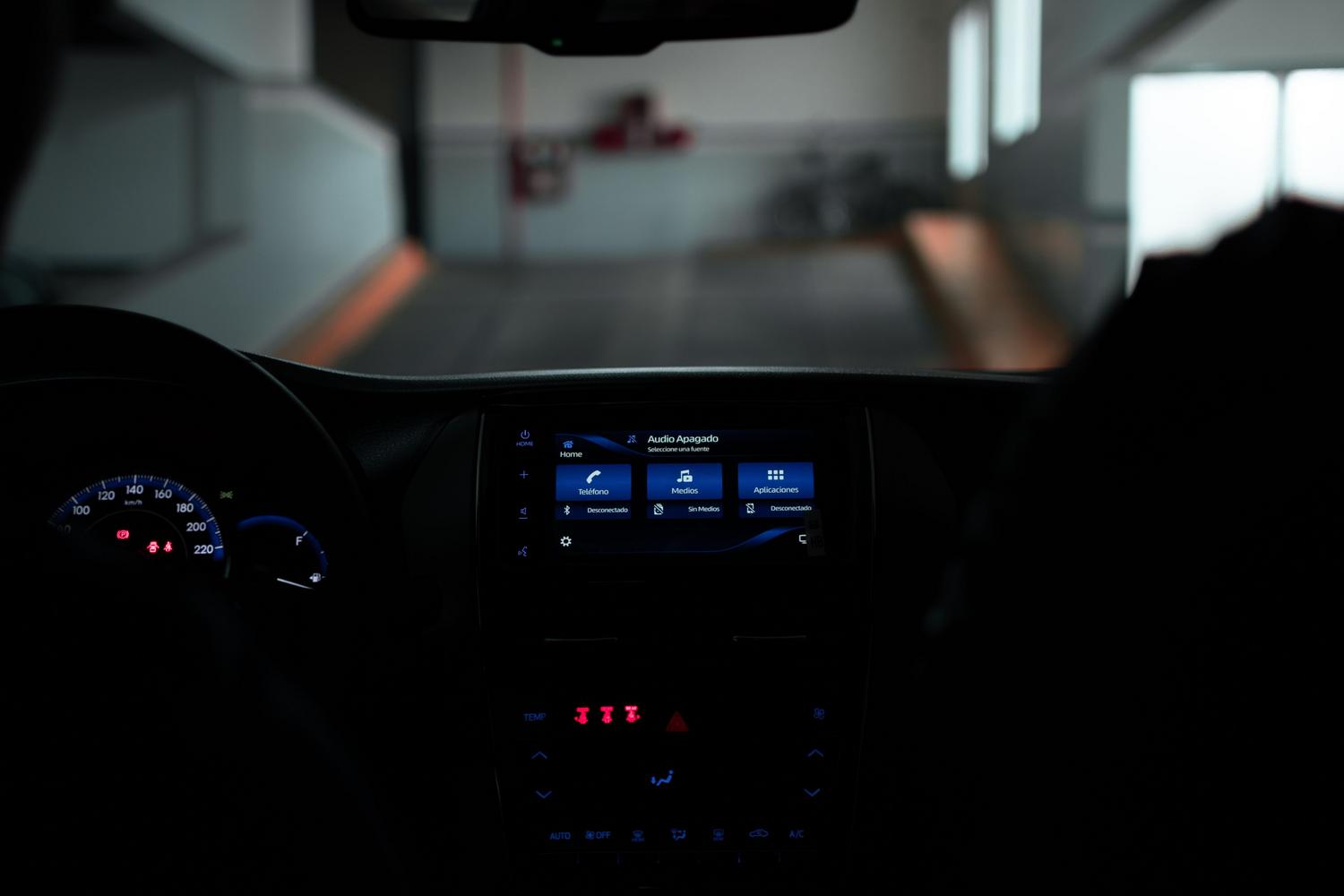 Vista interior de un salpicadero de coche moderno con la pantalla central iluminada