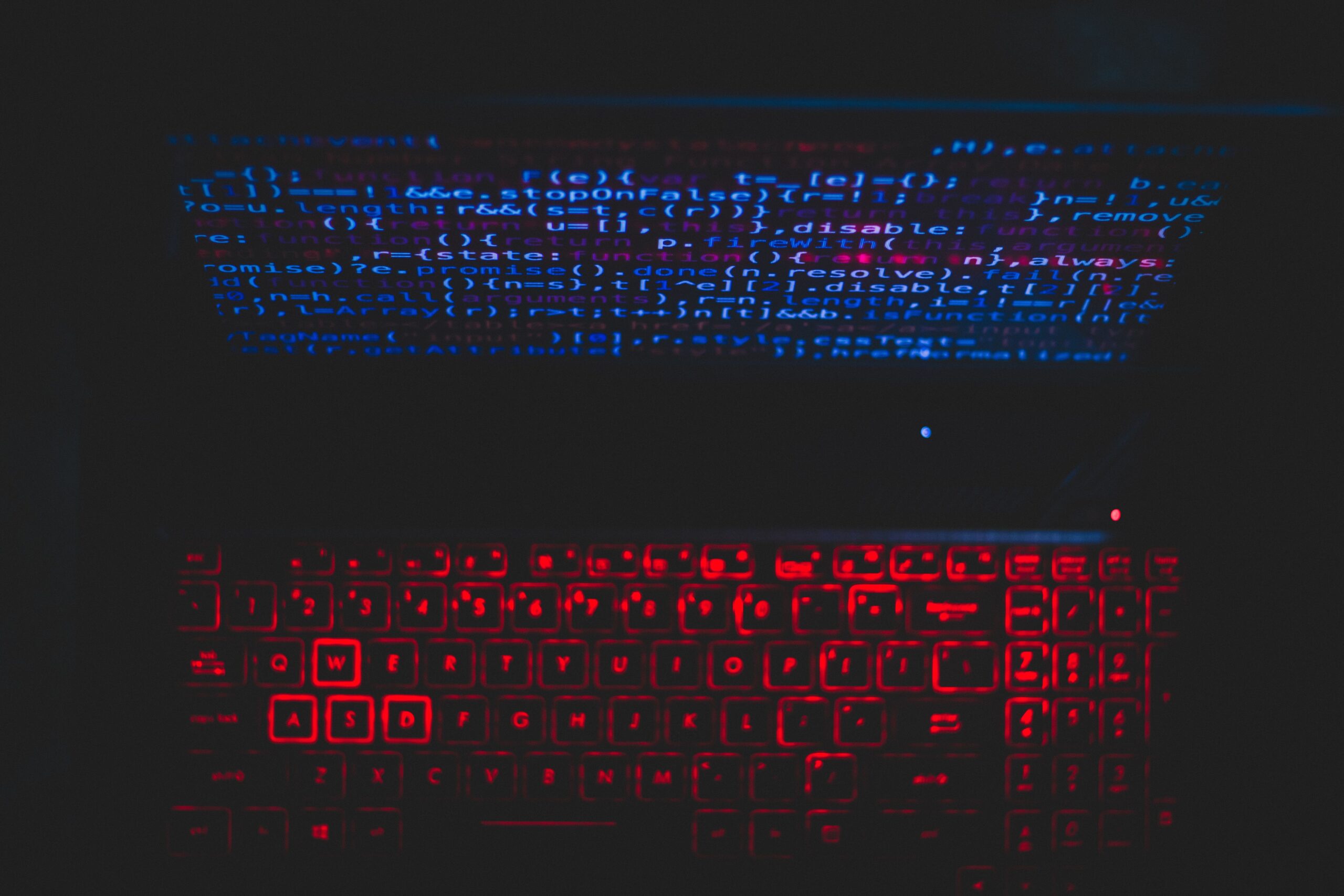 Configuración de portátil con teclado iluminado y código en pantalla, representando el uso de herramientas técnicas como Ollama.