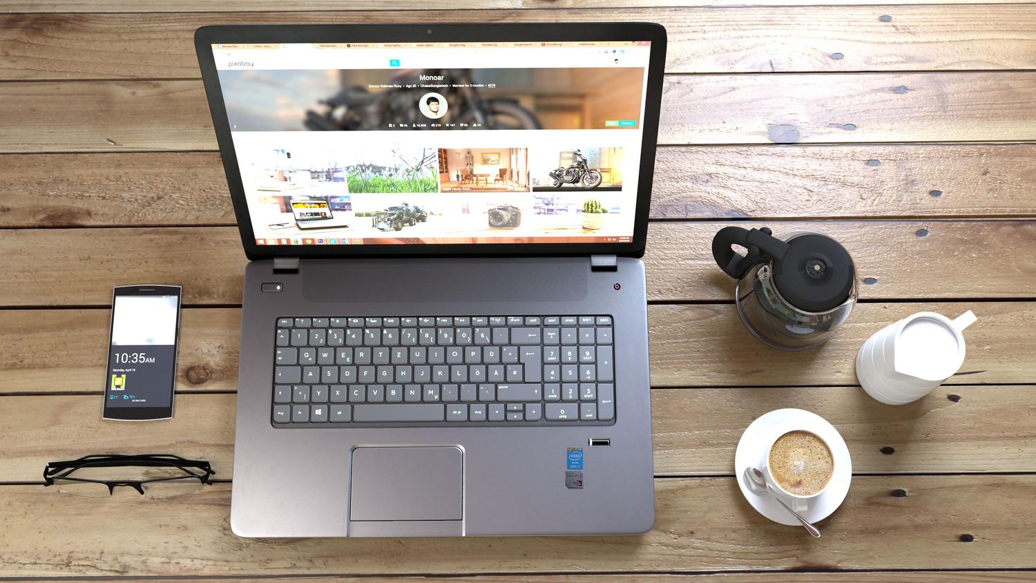 Espacio de trabajo con portátil y smartphone en un entorno relajado, simbolizando la capacidad de acceder a los datos del NAS desde cualquier lugar.