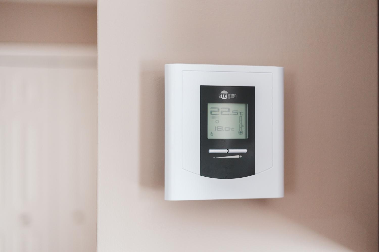 Termostato digital inteligente montado en la pared para el control eficiente de la temperatura y el consumo eléctrico.