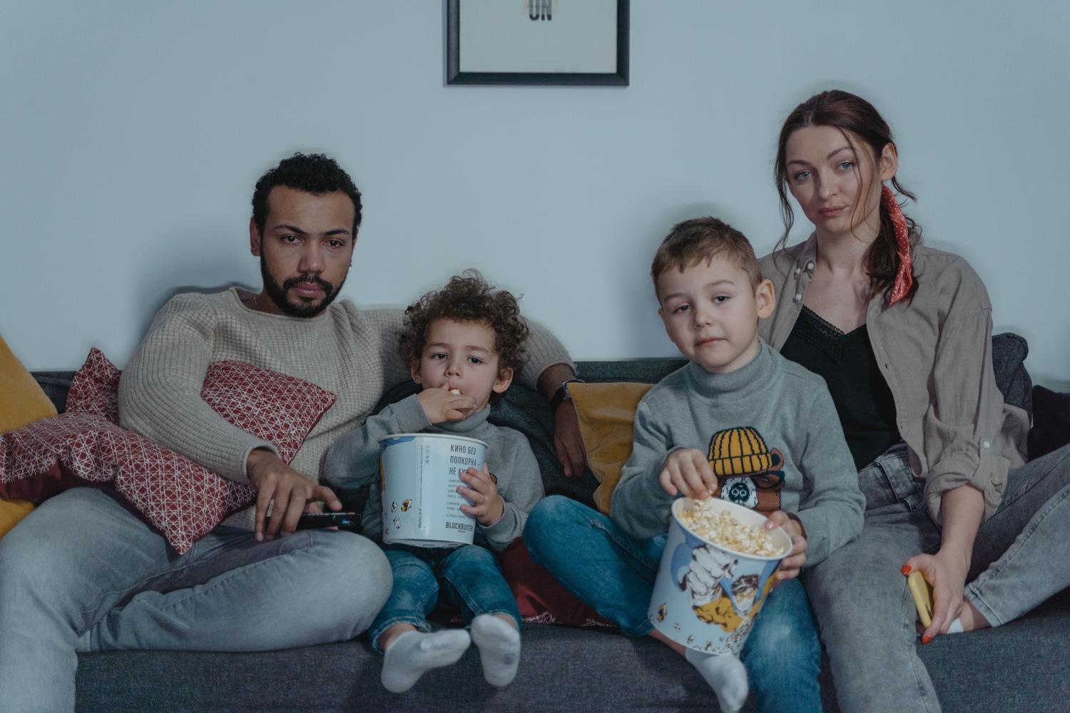 Familia disfrutando de una noche de cine con palomitas, ilustrando el ocio digital saludable y controlado en el hogar.