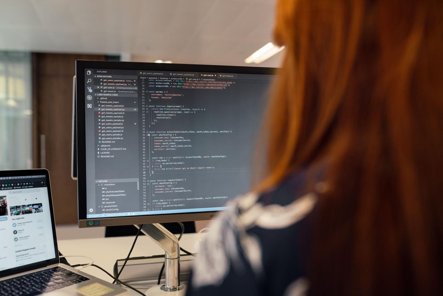 Desarrollador de software configurando un entorno de programación en monitores duales.