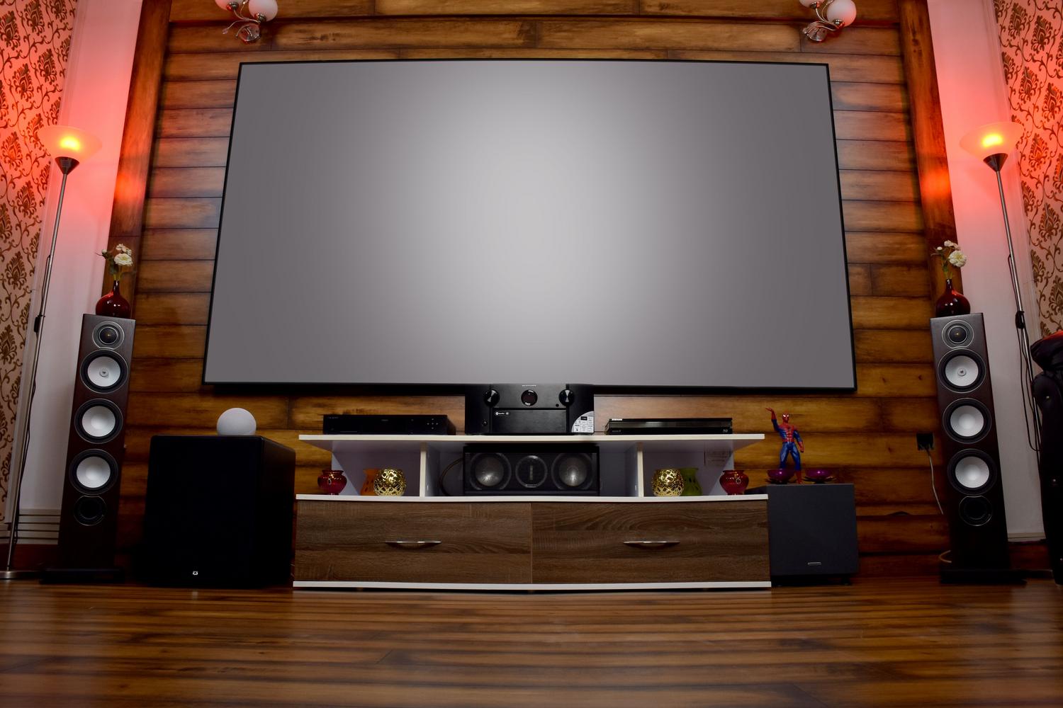 Sala de cine en casa con pantalla grande y sistema de sonido, ilustrando el centro de entretenimiento.