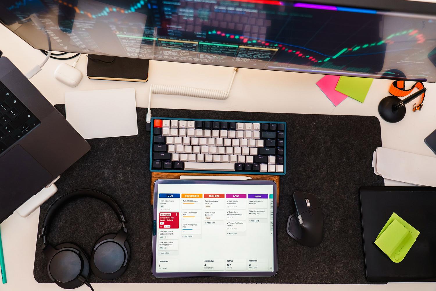 Vista cenital de un espacio de trabajo tecnológico con tablet y monitor, ideal para ilustrar la automatización de flujos de trabajo.