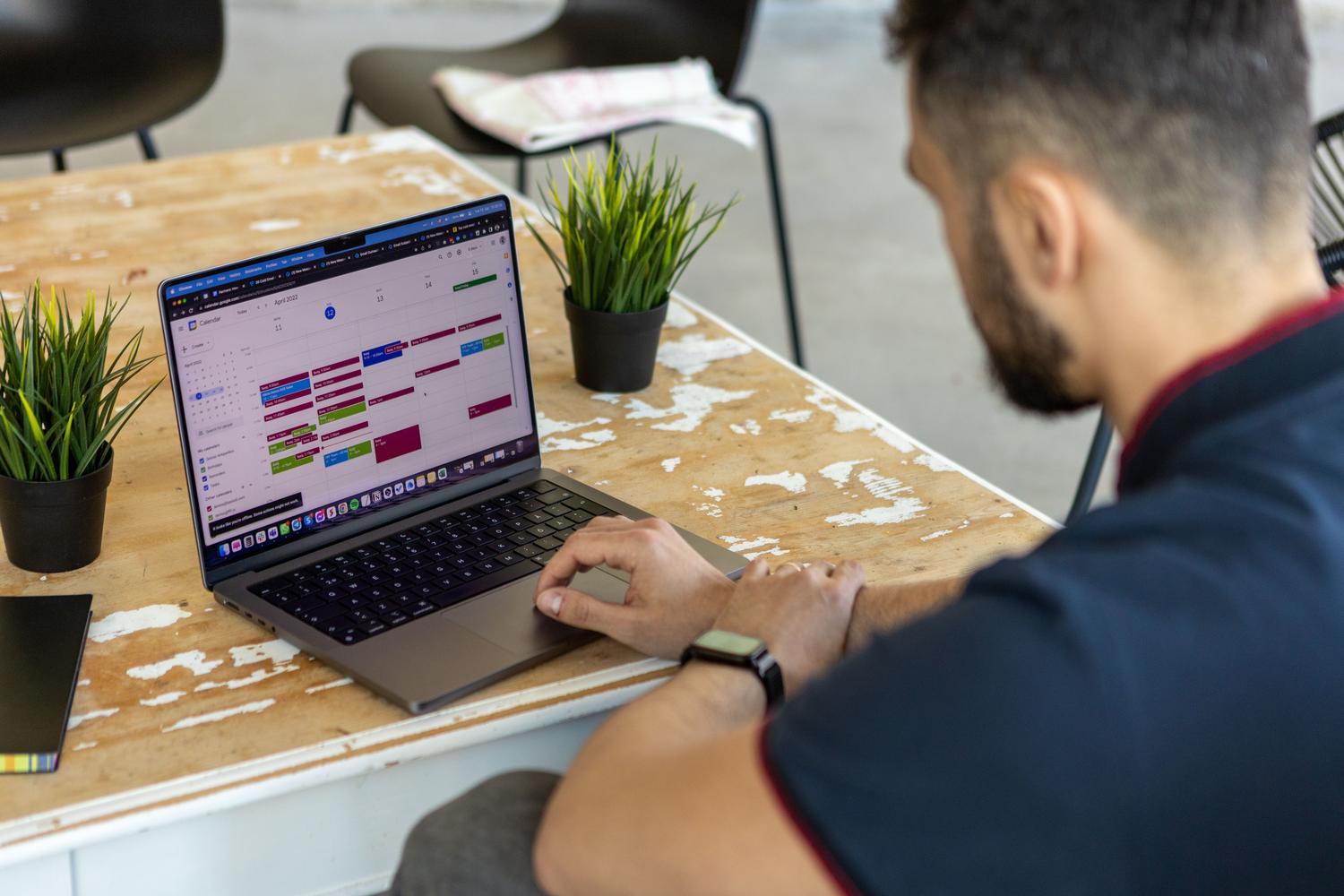 Persona organizando su agenda en un calendario digital, representando la planificación y optimización del tiempo.