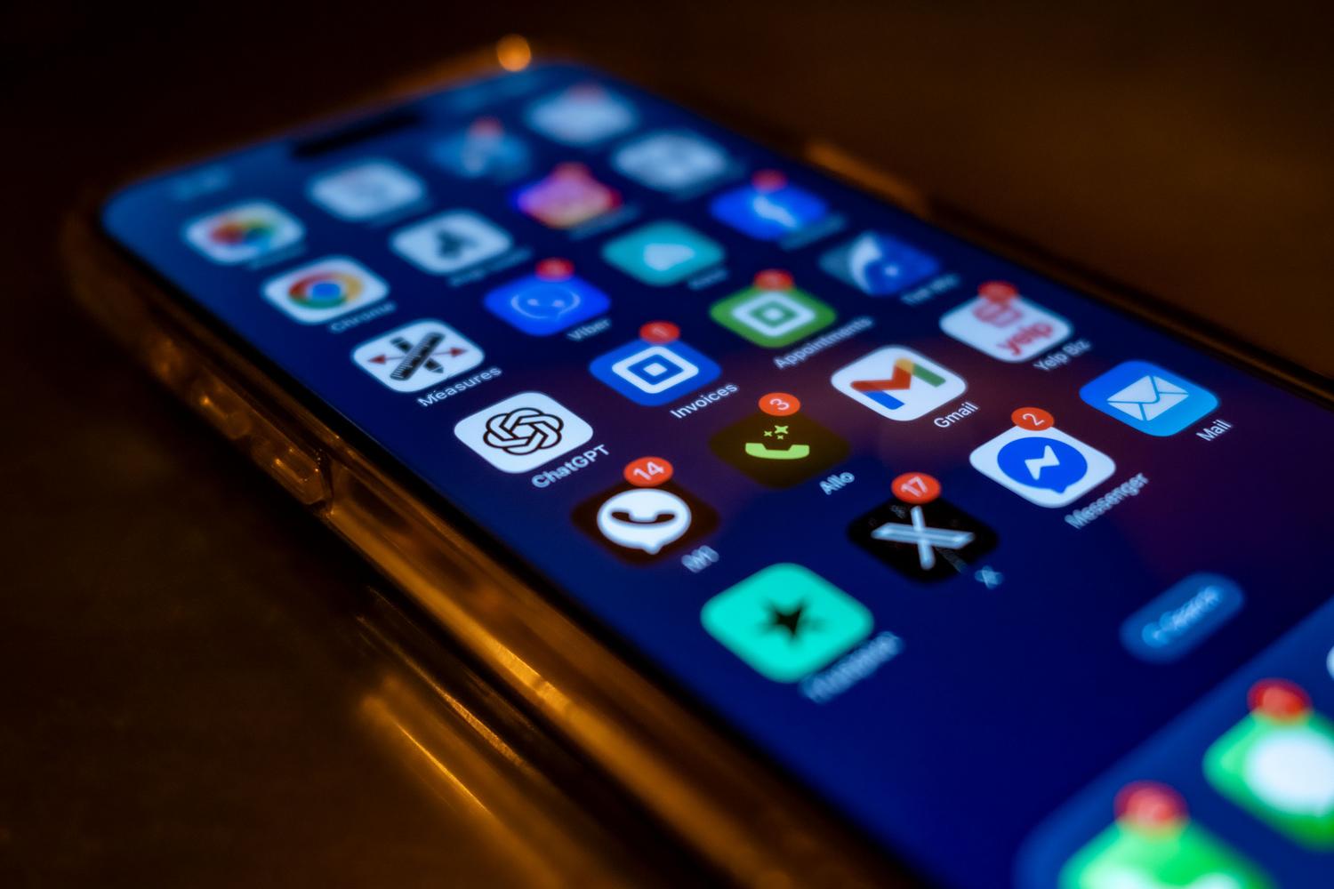 Primer plano de pantalla de smartphone con múltiples insignias de notificación rojas, simbolizando la saturación de alertas.