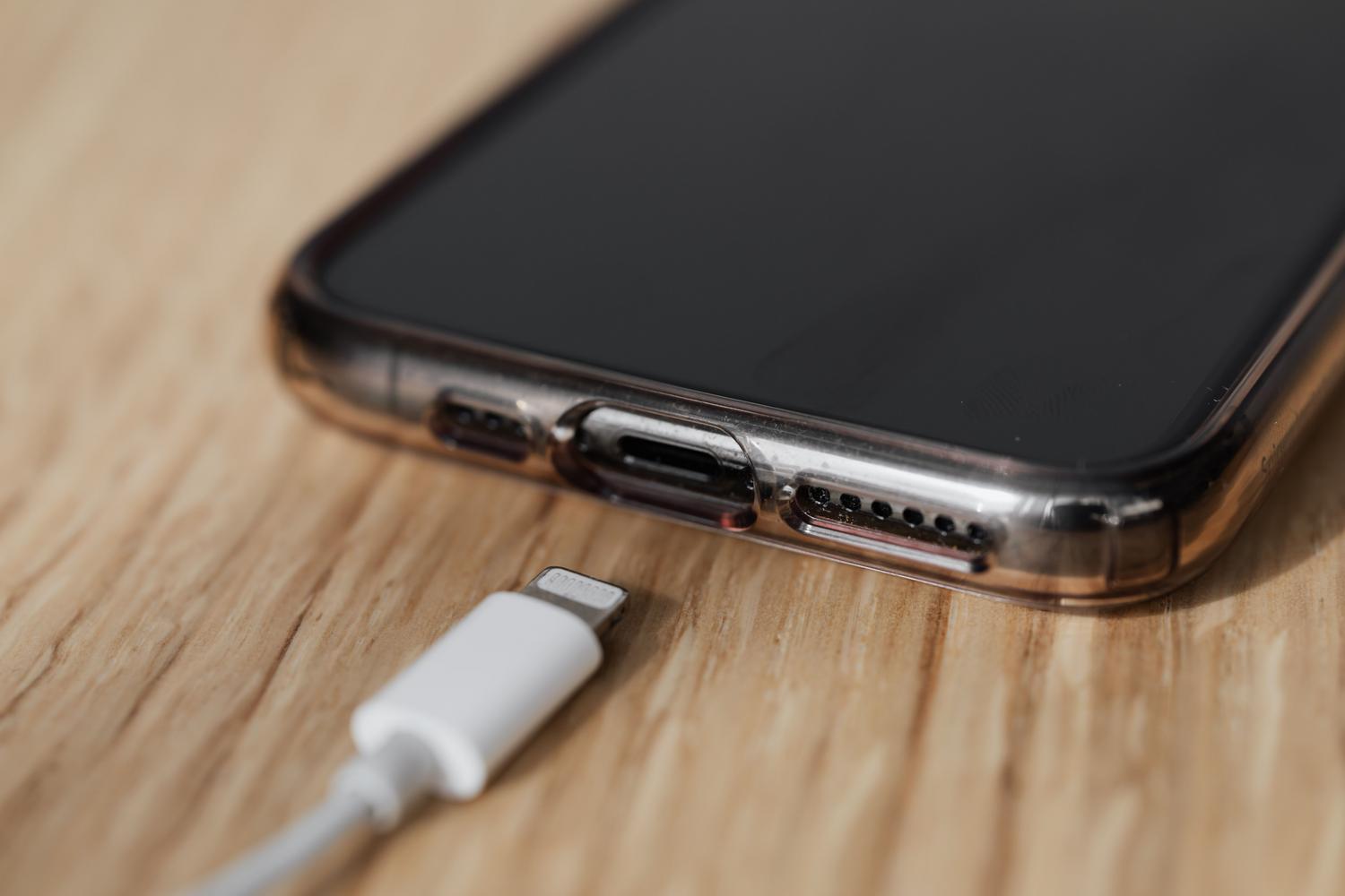 Primer plano de un puerto de carga de teléfono móvil y un conector USB, destacando la importancia de la limpieza del puerto.