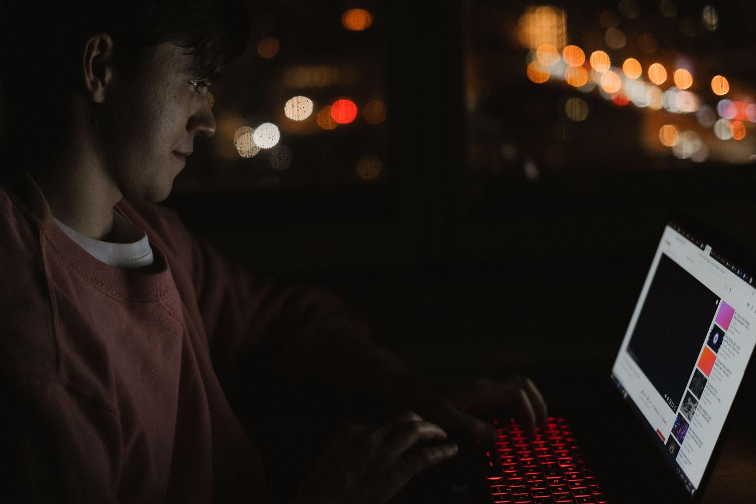 Persona trabajando en su ordenador durante la noche, ideal para programar actualizaciones fuera de horario