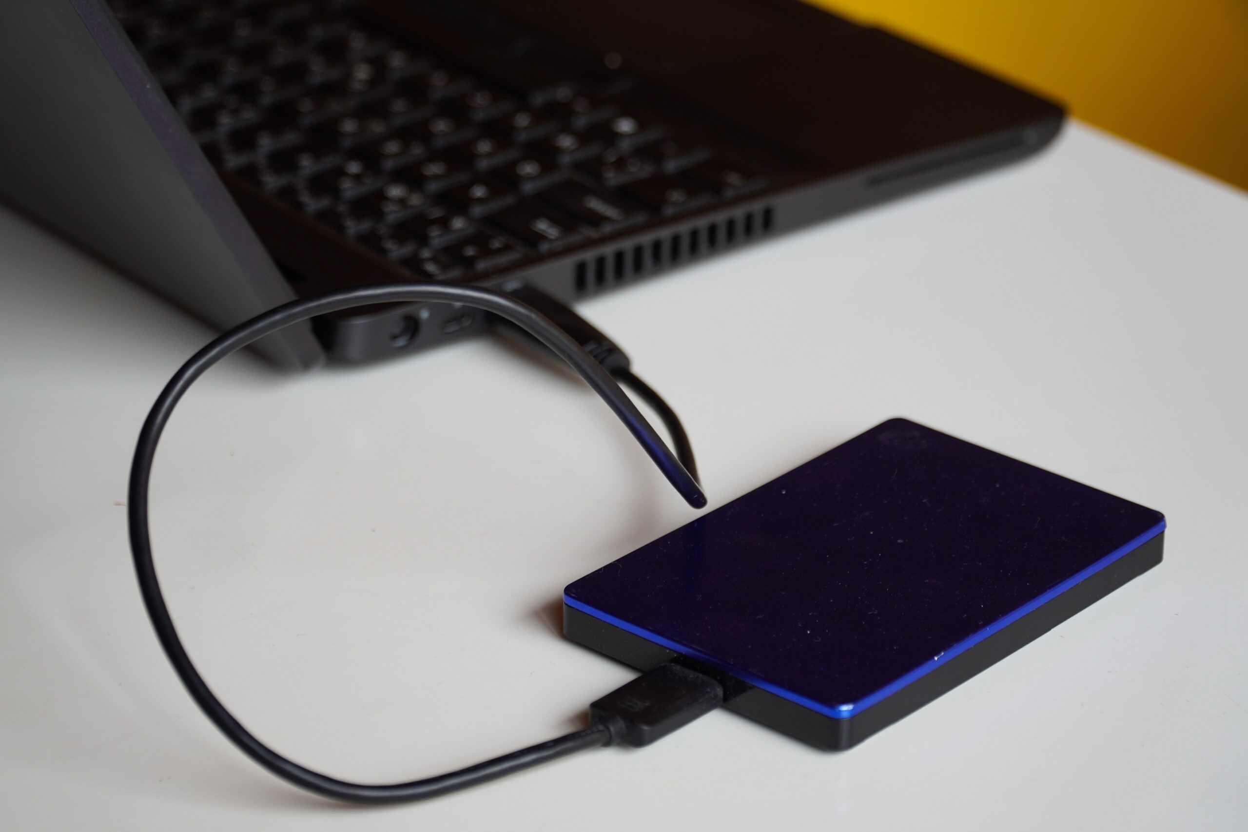 Disco duro externo conectado a un ordenador portátil, representando la implementación de la regla de respaldo 3-2-1 mencionada en el artículo.