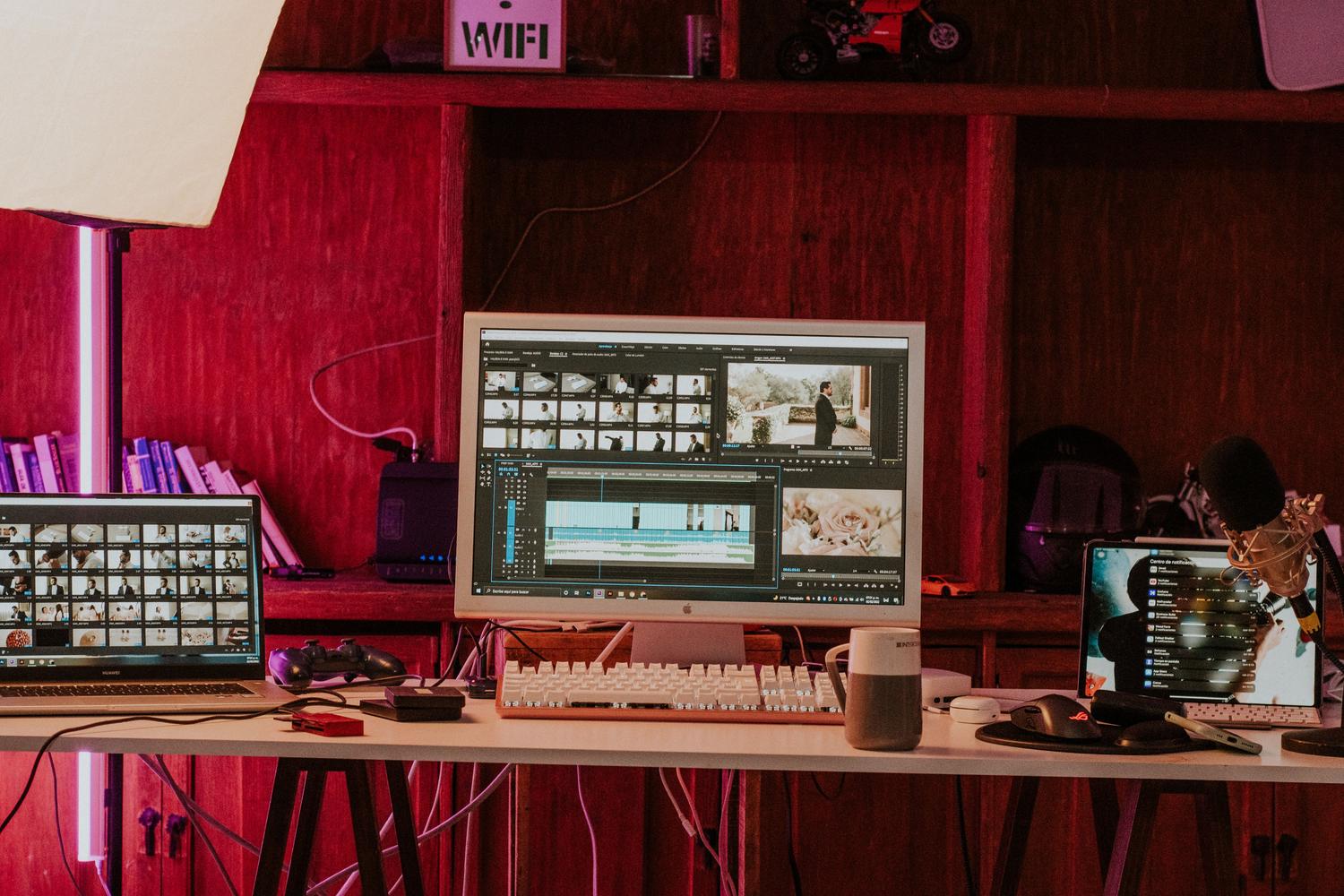 Estación de trabajo profesional de edición de vídeo con múltiples monitores en un estudio creativo.