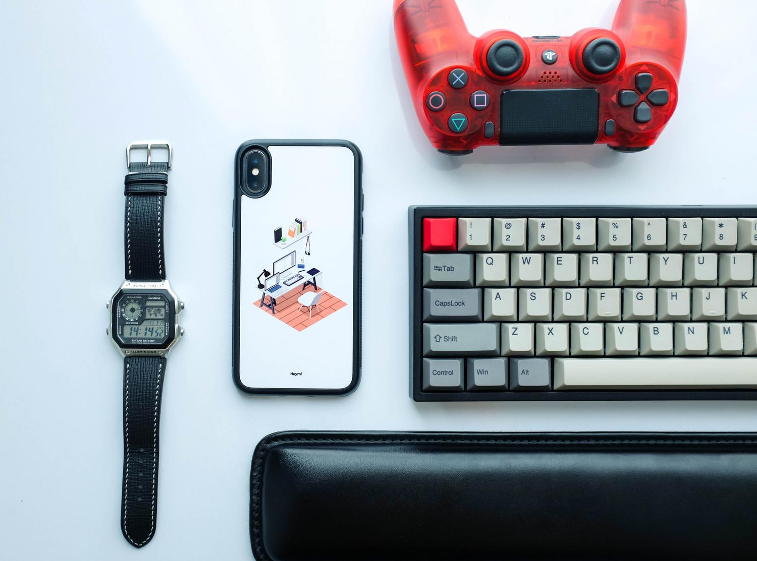 Composición zenital de un smartphone, mando de consola y teclado, representando la conectividad entre dispositivos.
