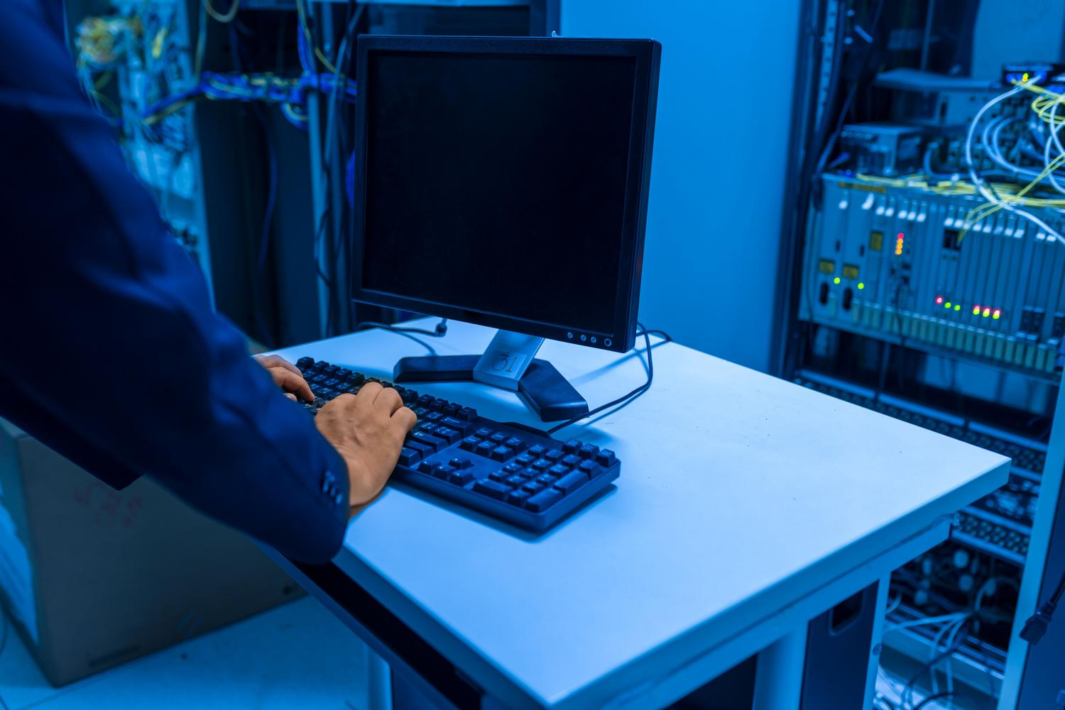 Técnico de IT administrando sistemas en una sala de servidores, ilustrando la gestión del software de SAI.