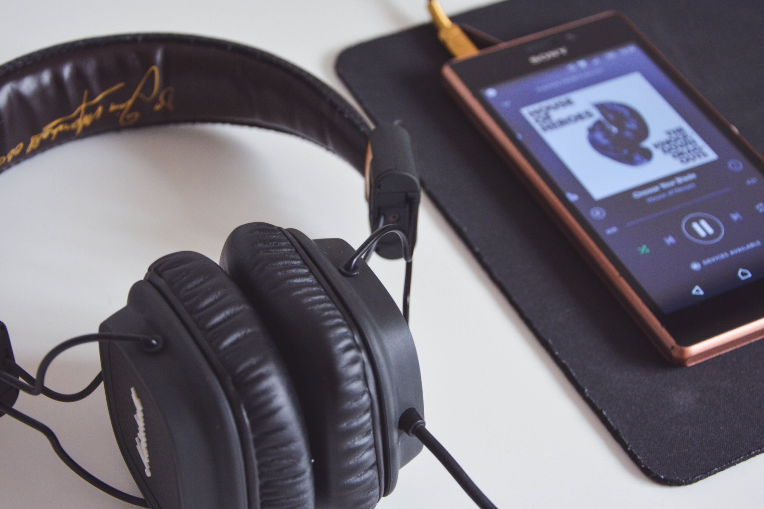 Auriculares y smartphone sobre una mesa, ideal para ilustrar la configuración de perfiles de audio.