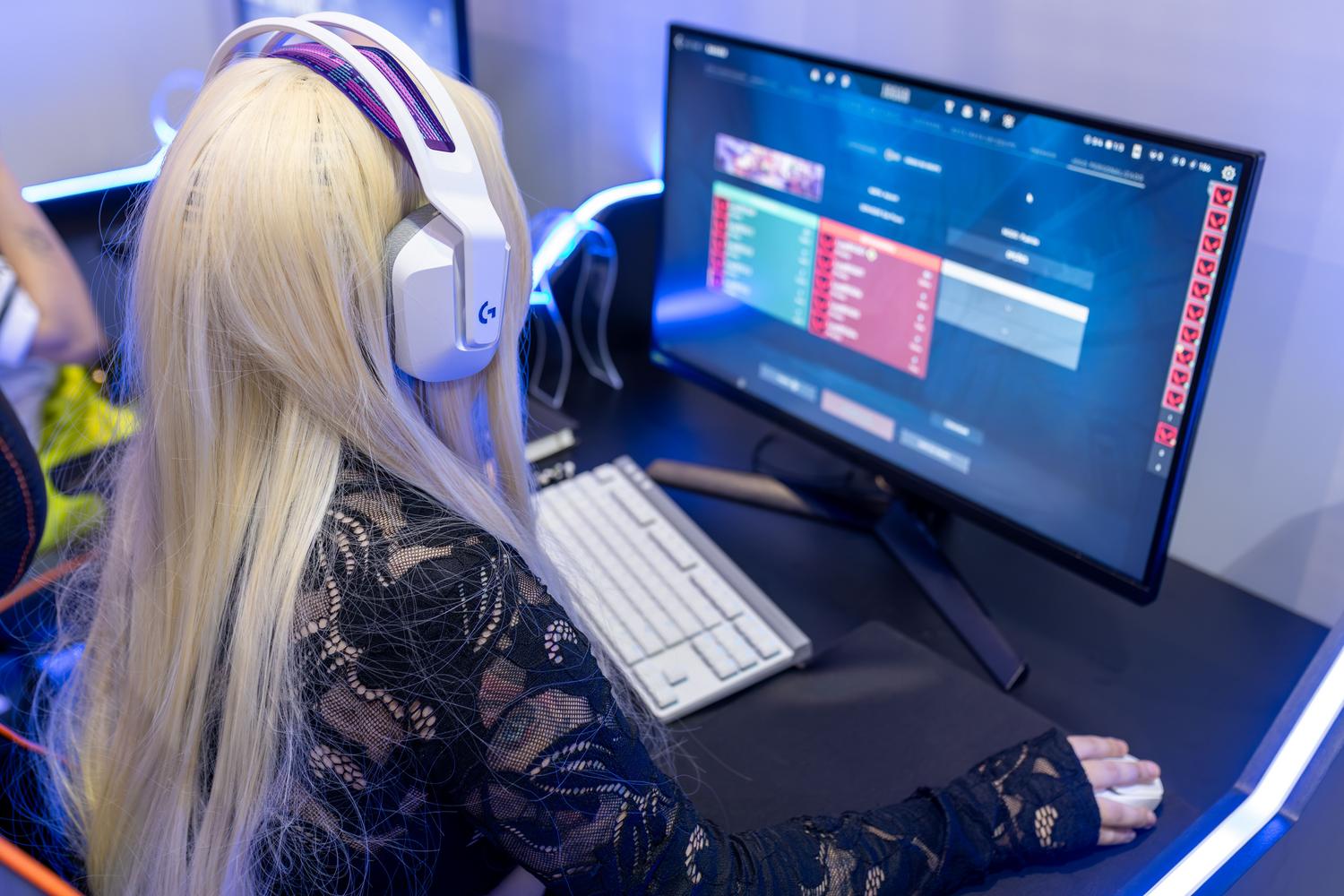 Jugadora utilizando un setup de PC optimizado con auriculares y periféricos gaming