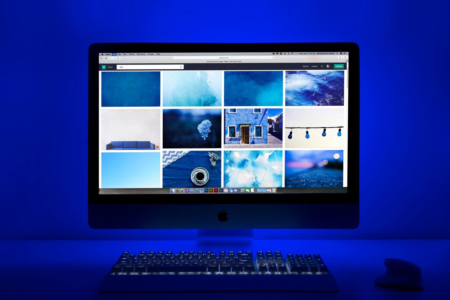 Espacio de trabajo moderno con monitor mostrando una galería de imágenes, ideal para ilustrar la elección de fondos de pantalla y presentaciones de diapositivas.