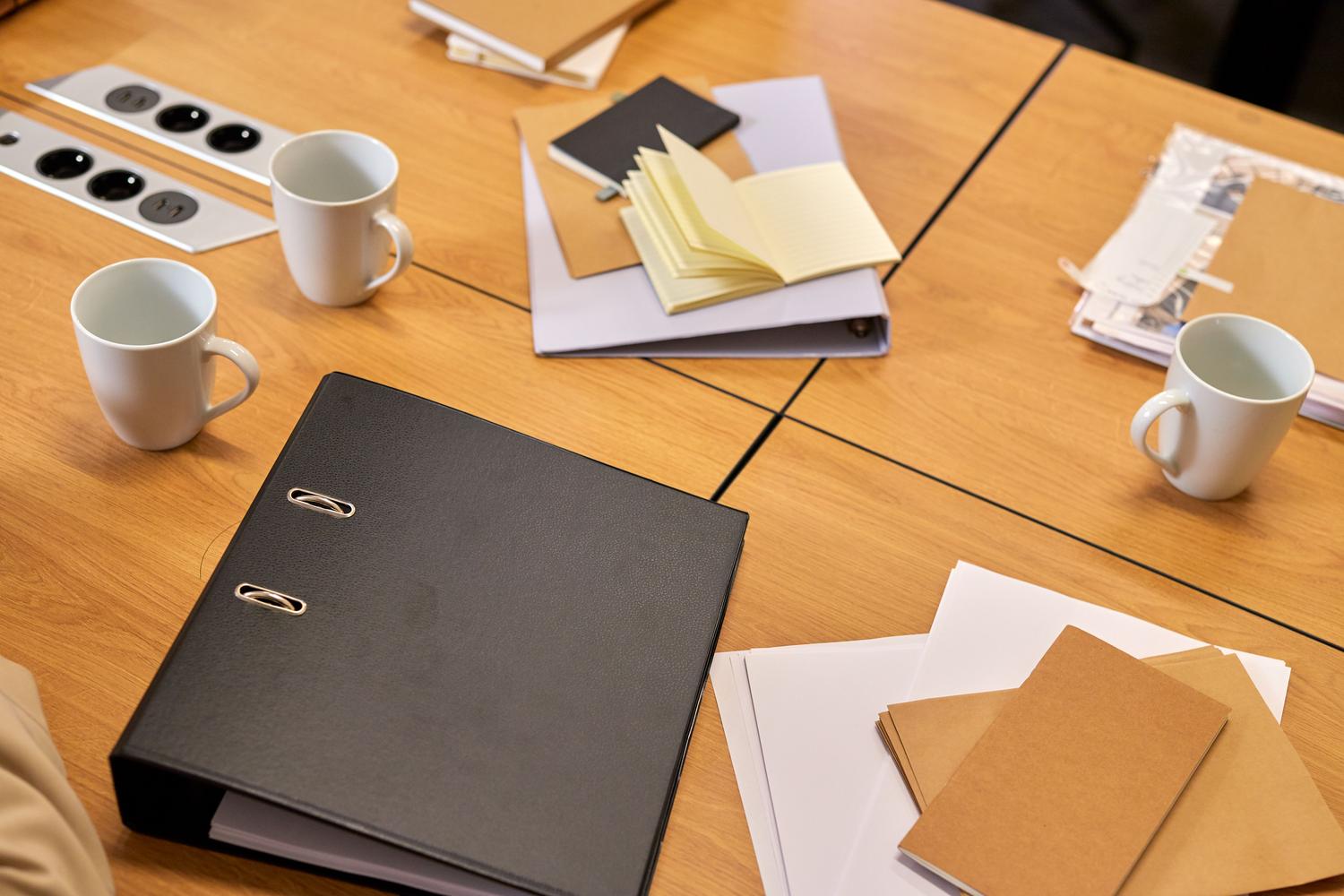 Escritorio de oficina organizado con carpetas, documentos y material de papelería, transmitiendo una imagen de seriedad y eficiencia administrativa.