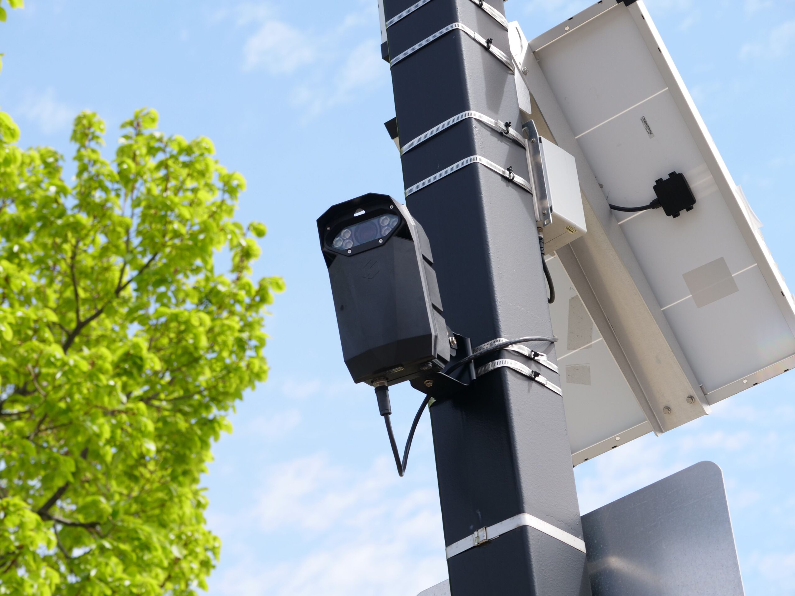 Cámara de vigilancia urbana alimentada por panel solar, resistente a condiciones climáticas extremas.