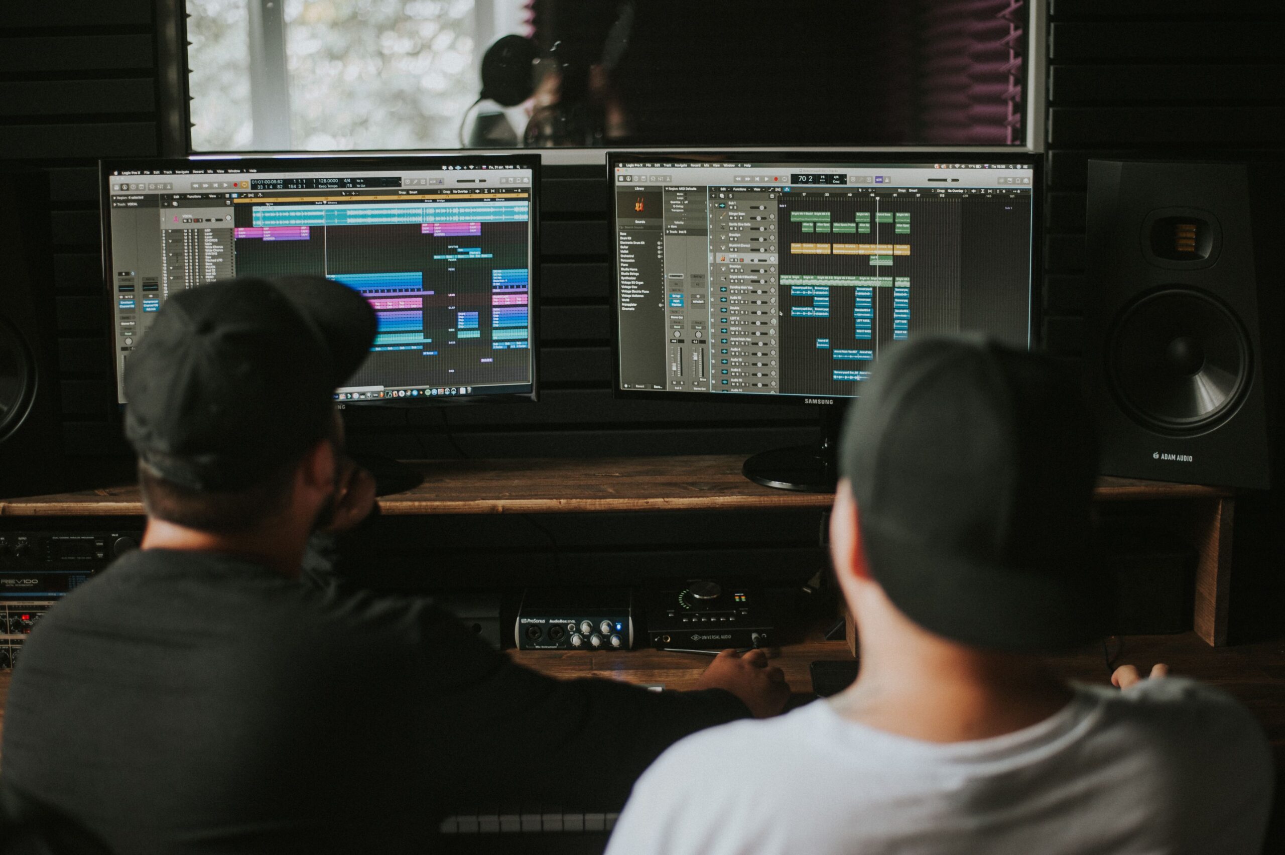 Ingenieros de sonido trabajando en una sesión de mezcla en un estudio de grabación profesional con monitores de audio.