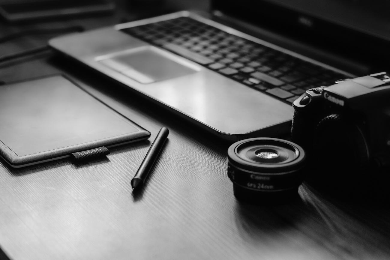 Espacio de trabajo profesional con cámara DSLR y portátil, representando el hardware y software necesarios para la compatibilidad de cámaras en Linux.