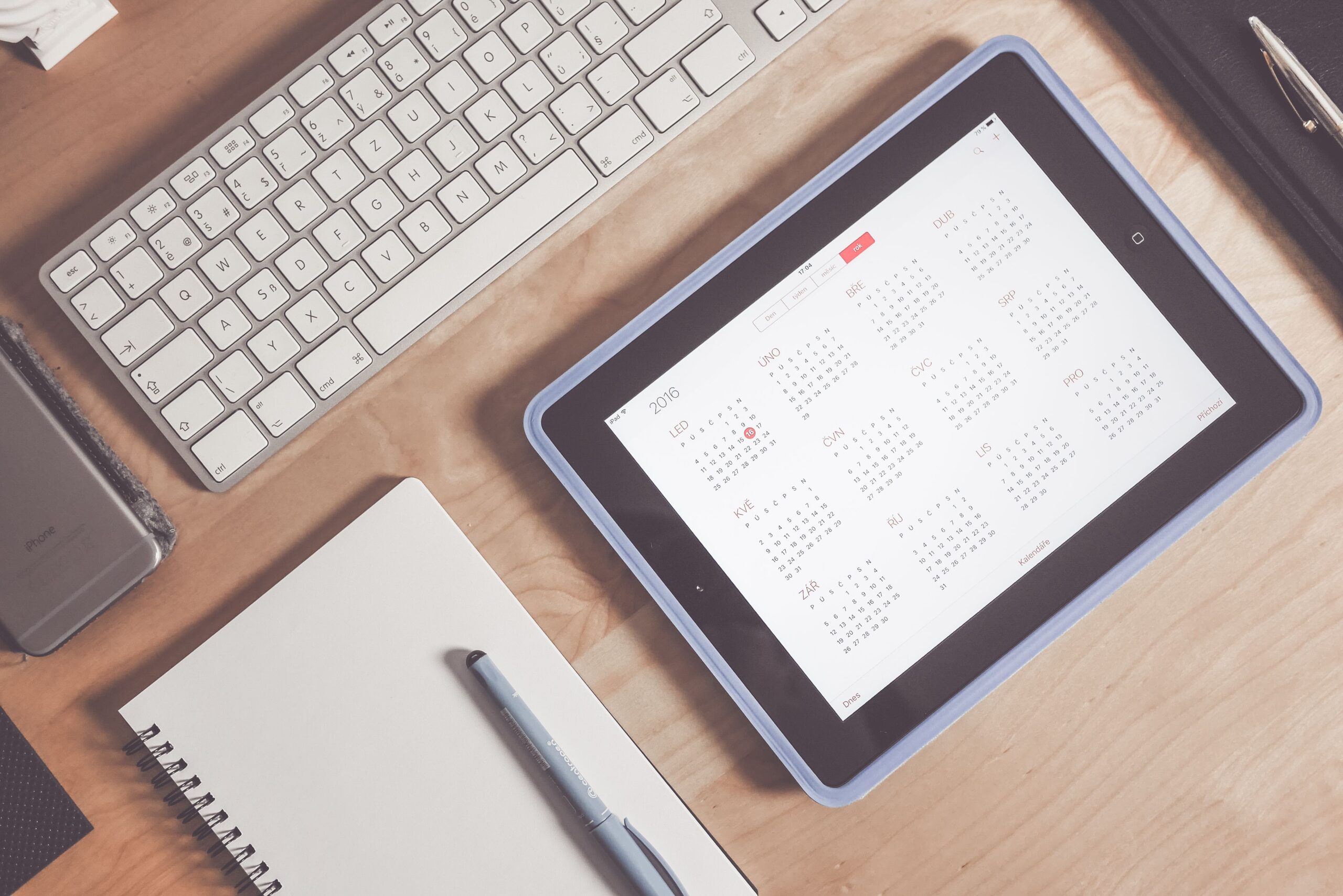 Escritorio organizado con una tablet mostrando un calendario, representando el estado ideal de una agenda sincronizada correctamente.