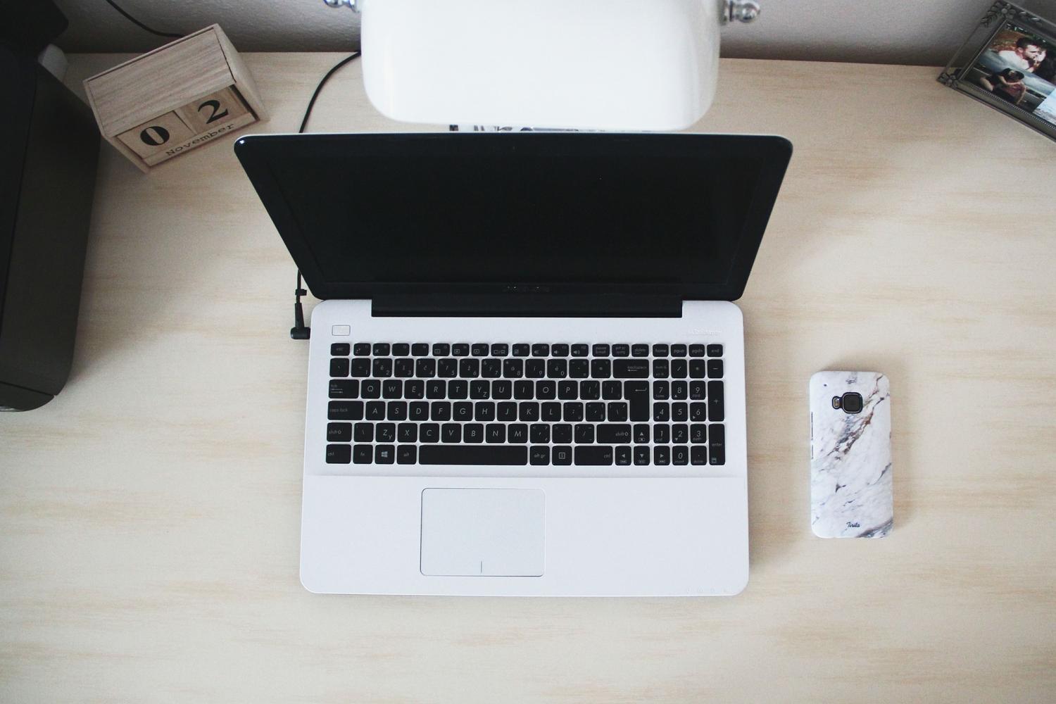 Espacio de trabajo tecnológico moderno y minimalista con un portátil y un smartphone, ideal para contextualizar el uso de herramientas de transferencia de datos.