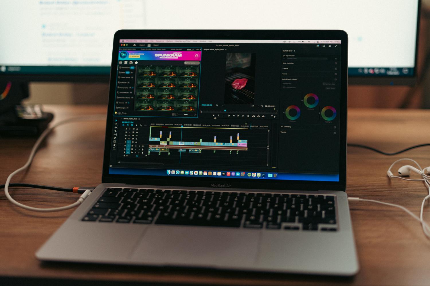 Espacio de trabajo con un ordenador portátil y software de edición de vídeo abierto, representando el proceso de compresión con HandBrake.