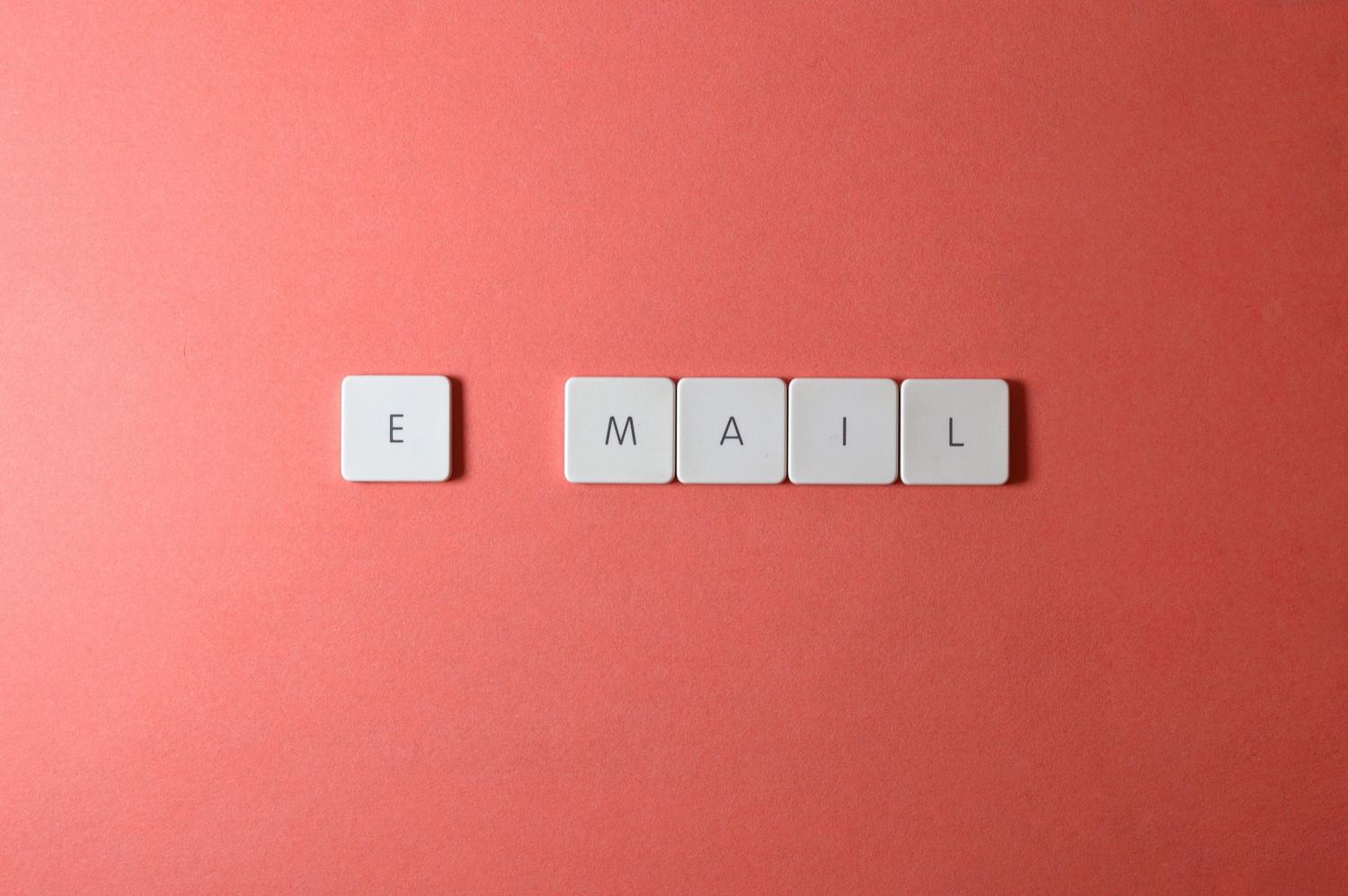 Letras de teclado formando la palabra 'email' sobre un fondo colorido, representando la comunicación electrónica.