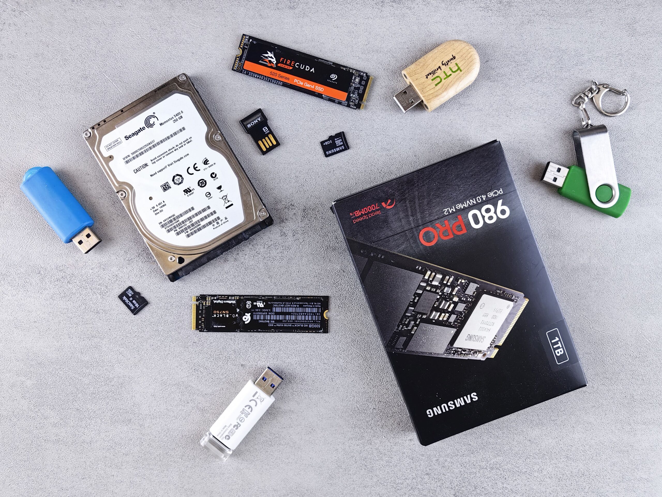 Colección organizada de diversos dispositivos de almacenamiento digital, incluyendo SSD NVMe y discos tradicionales, para dar contexto general al contenido.