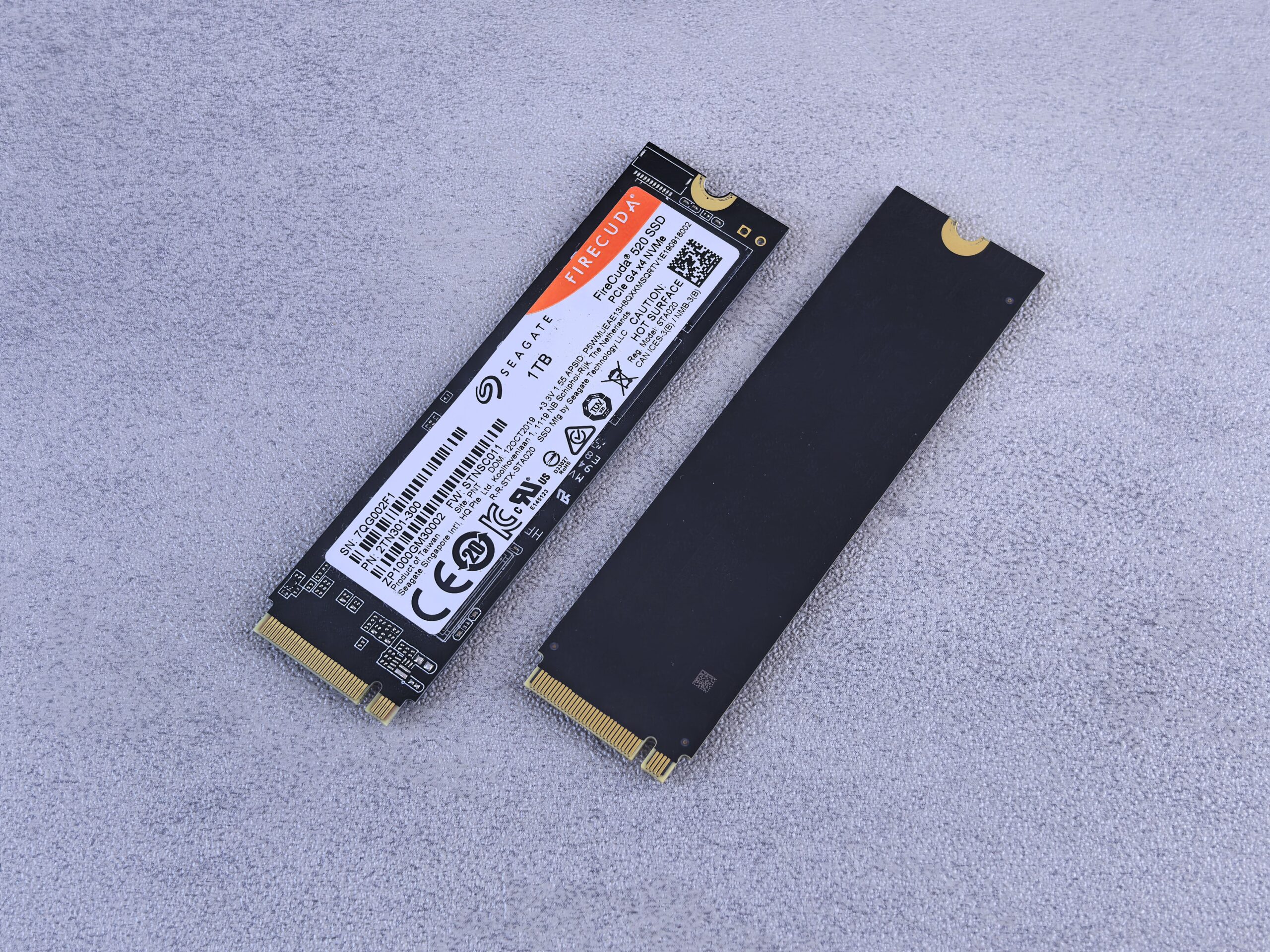 Primer plano de dos unidades SSD NVMe de alto rendimiento sobre un fondo neutro, destacando el diseño moderno del hardware.